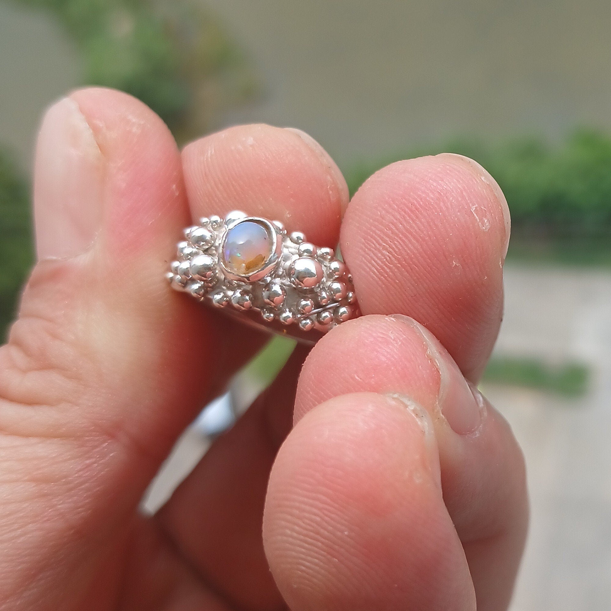 A beautiful handcrafted sterling silver Opal Ring featuring an oval-shaped opal with vibrant colors, elegantly polished for a sophisticated look.