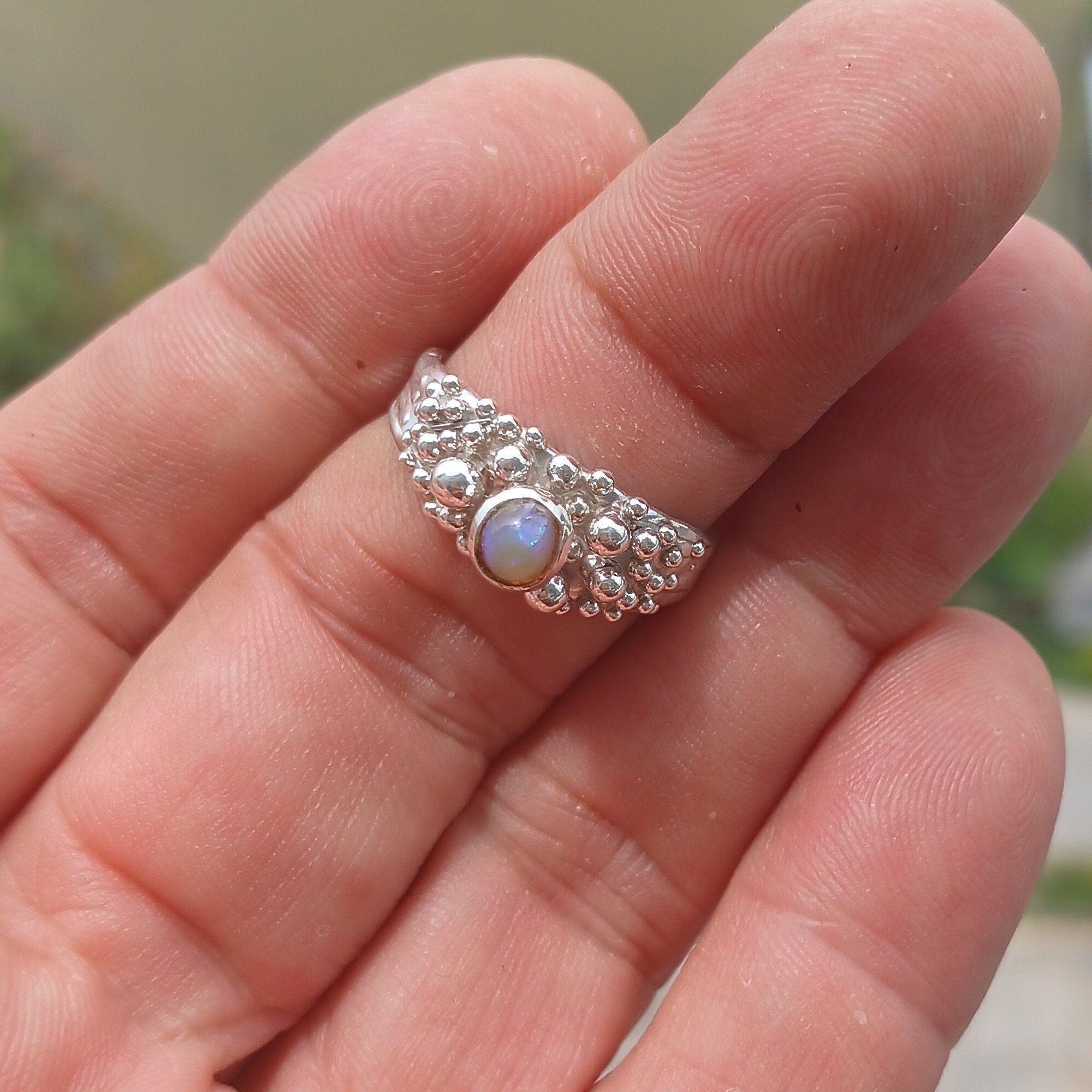 A beautiful handcrafted sterling silver Opal Ring featuring an oval-shaped opal with vibrant colors, elegantly polished for a sophisticated look.