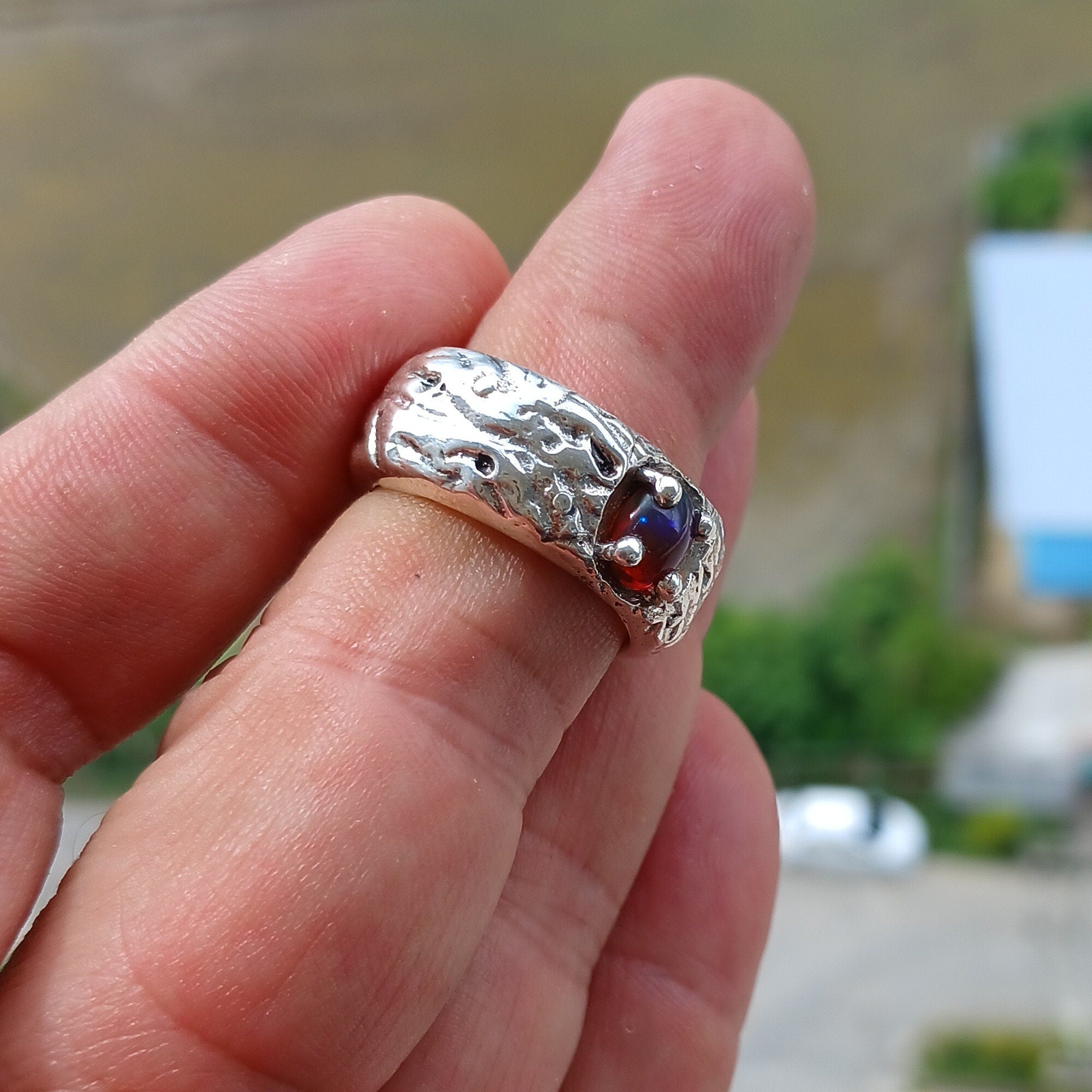 A handcrafted sterling silver ring featuring a vibrant multi-color opal stone, elegantly polished for a timeless look.