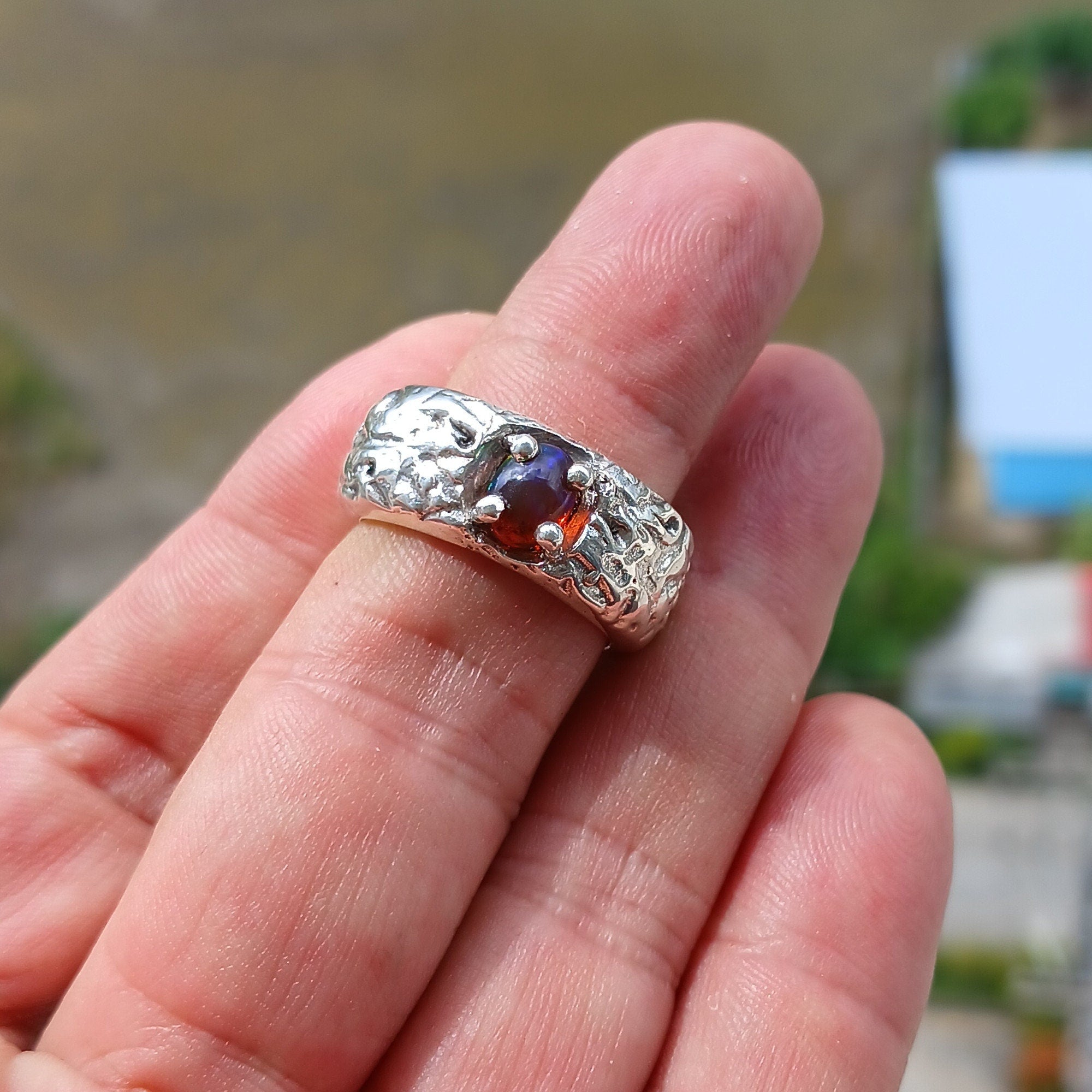 A handcrafted sterling silver ring featuring a vibrant multi-color opal stone, elegantly polished for a timeless look.