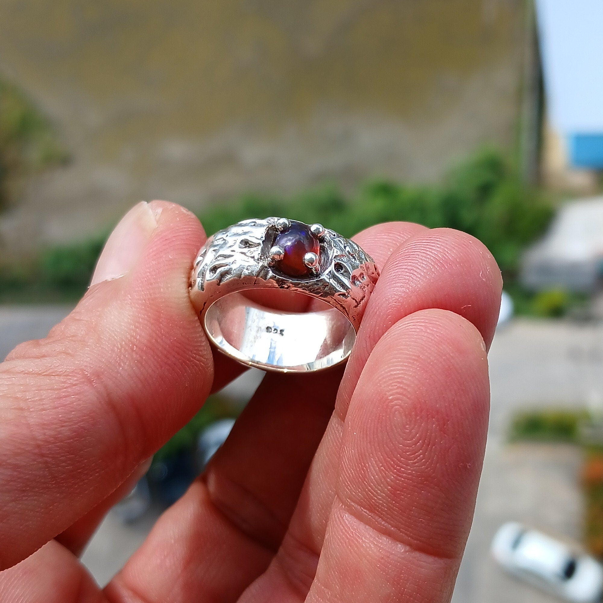 A handcrafted sterling silver ring featuring a vibrant multi-color opal stone, elegantly polished for a timeless look.