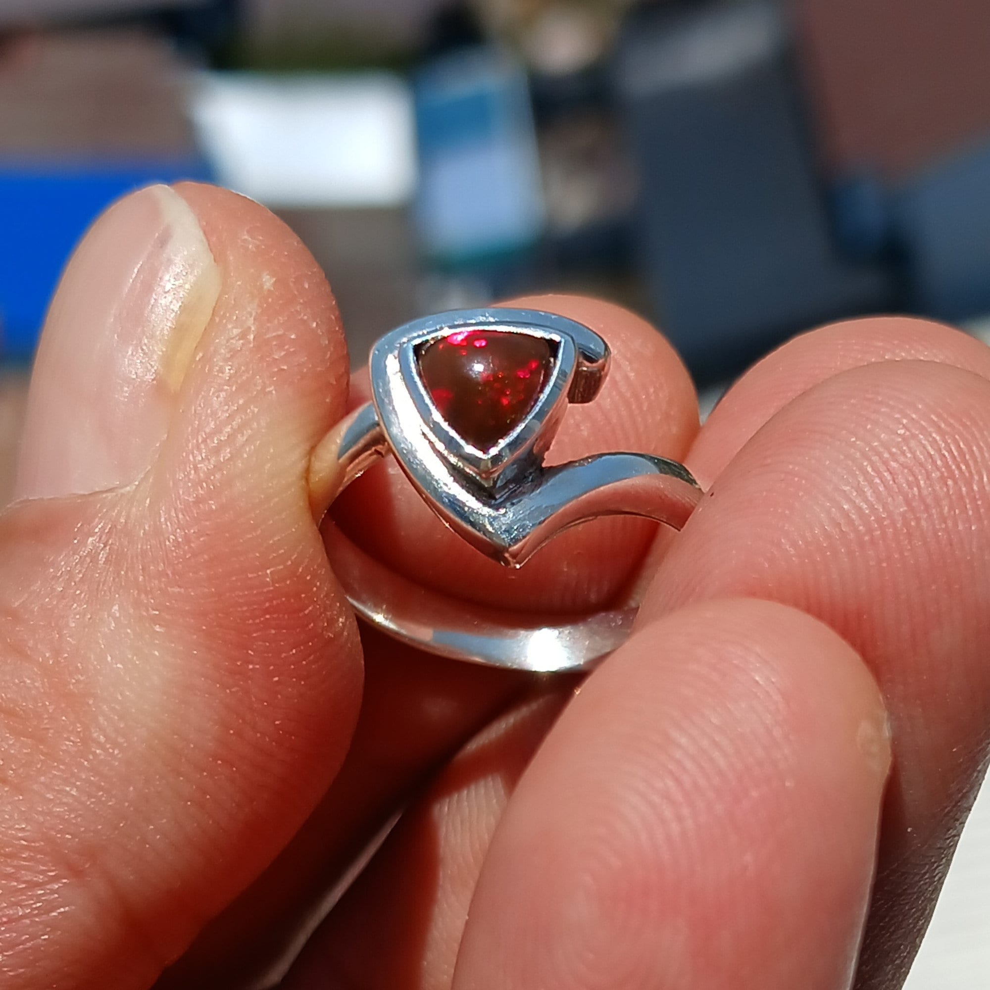 A stunning triangle-shaped Opal Ring set in high-quality sterling silver, showcasing a vibrant play of colors.