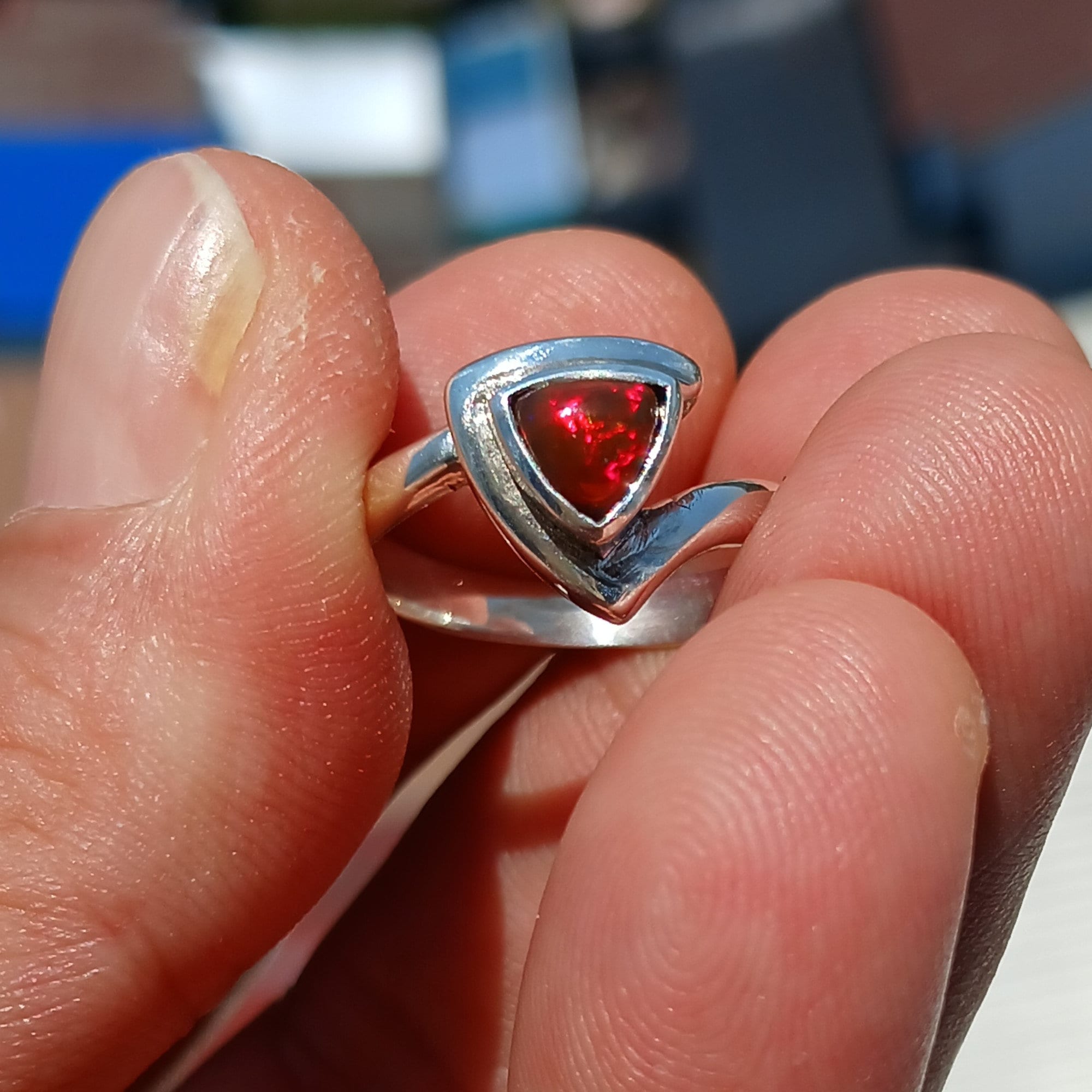 A stunning triangle-shaped Opal Ring set in high-quality sterling silver, showcasing a vibrant play of colors.