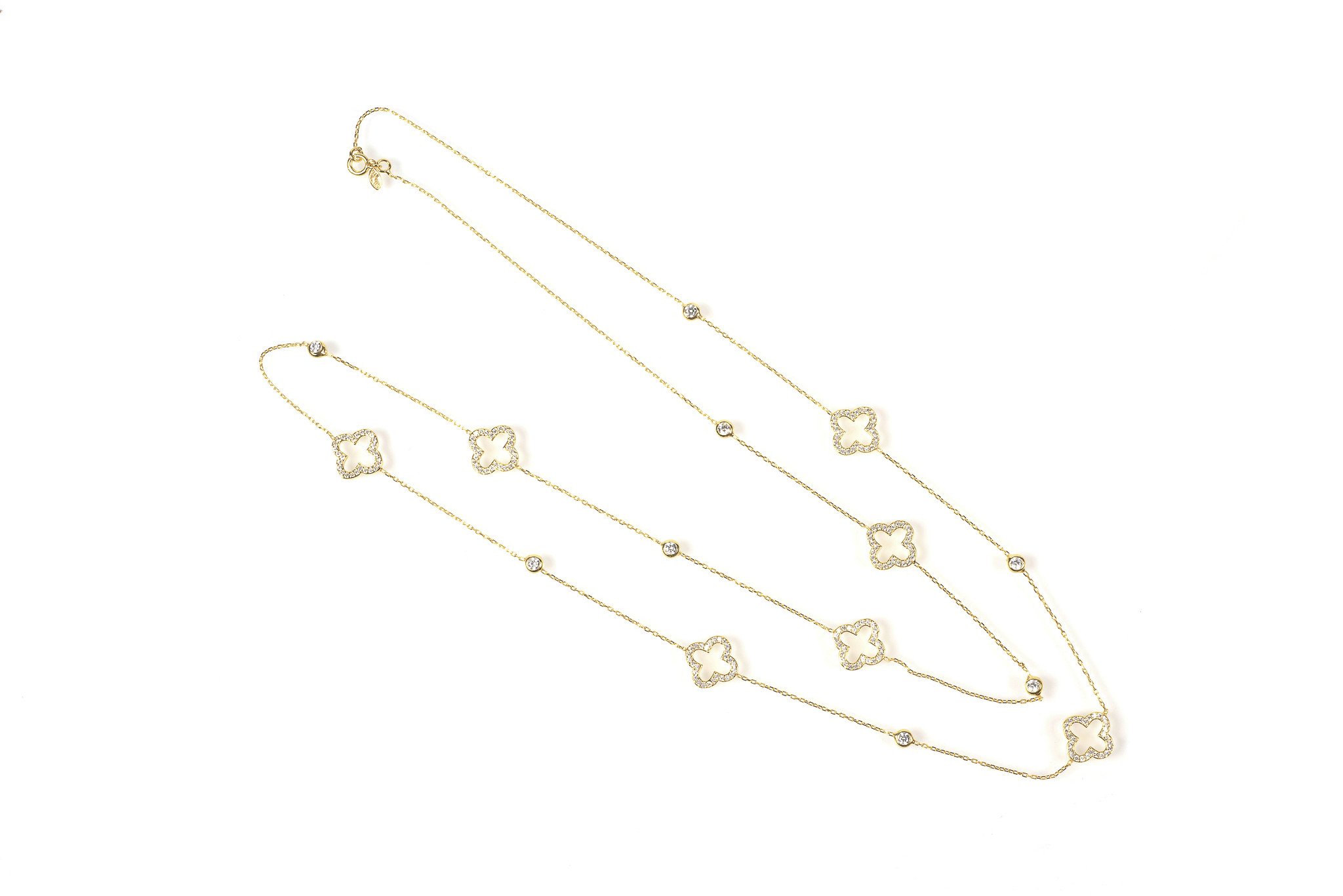 Open Clover Long Necklace in Gold with clover motifs and white zircons, elegantly displayed in a jewellery box.