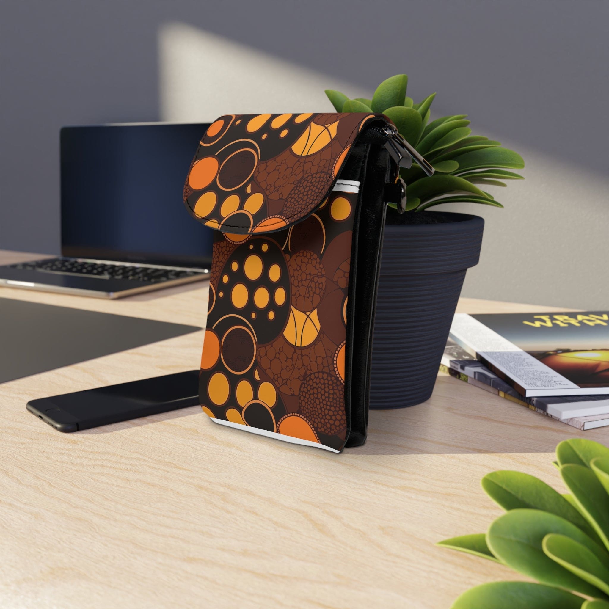 Orange and brown spotted crossbody cell phone wallet with adjustable strap and card slots.