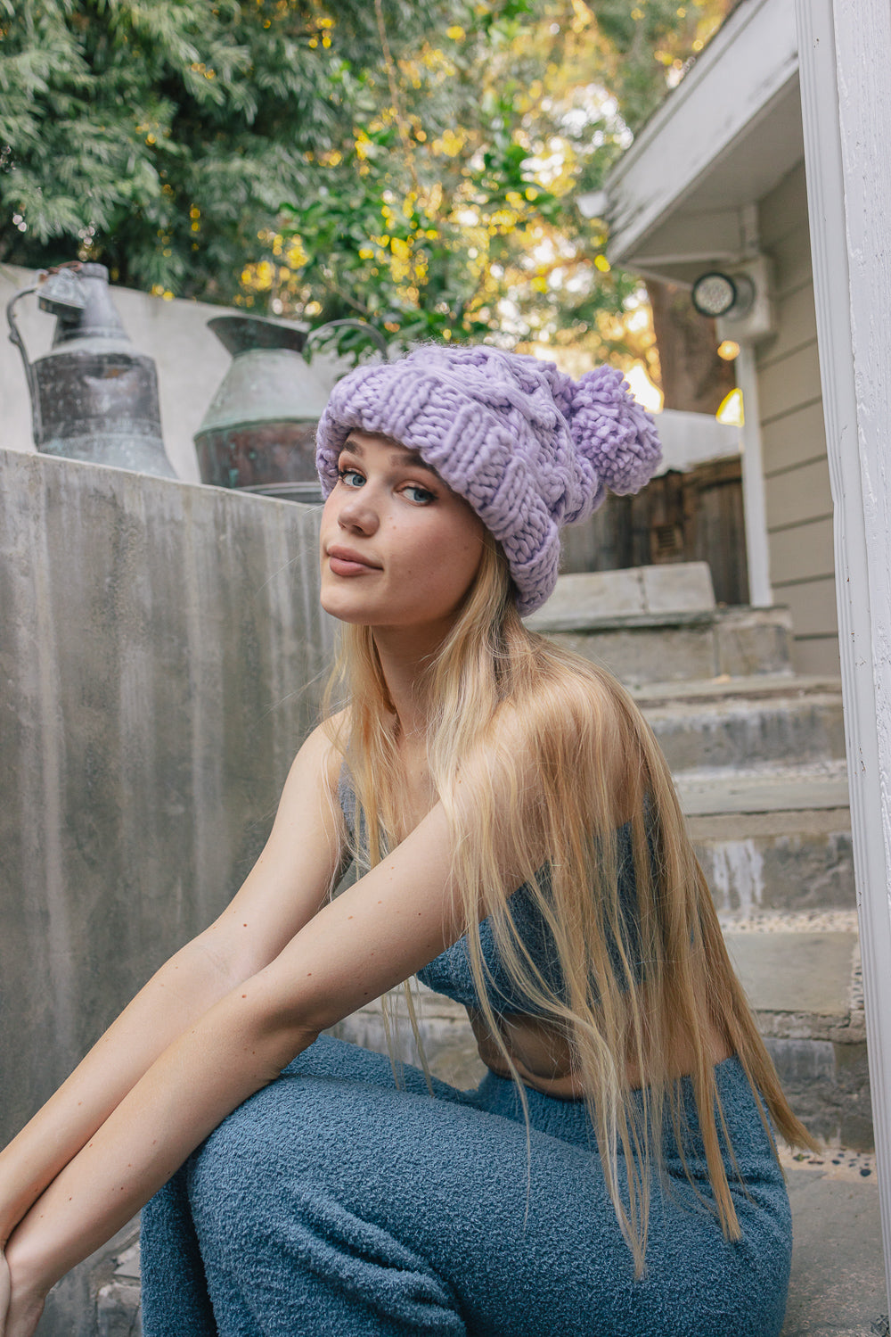 A stylish oversized chunky knit pom beanie in a cozy winter setting, featuring a playful pom on top and a chunky knit design.