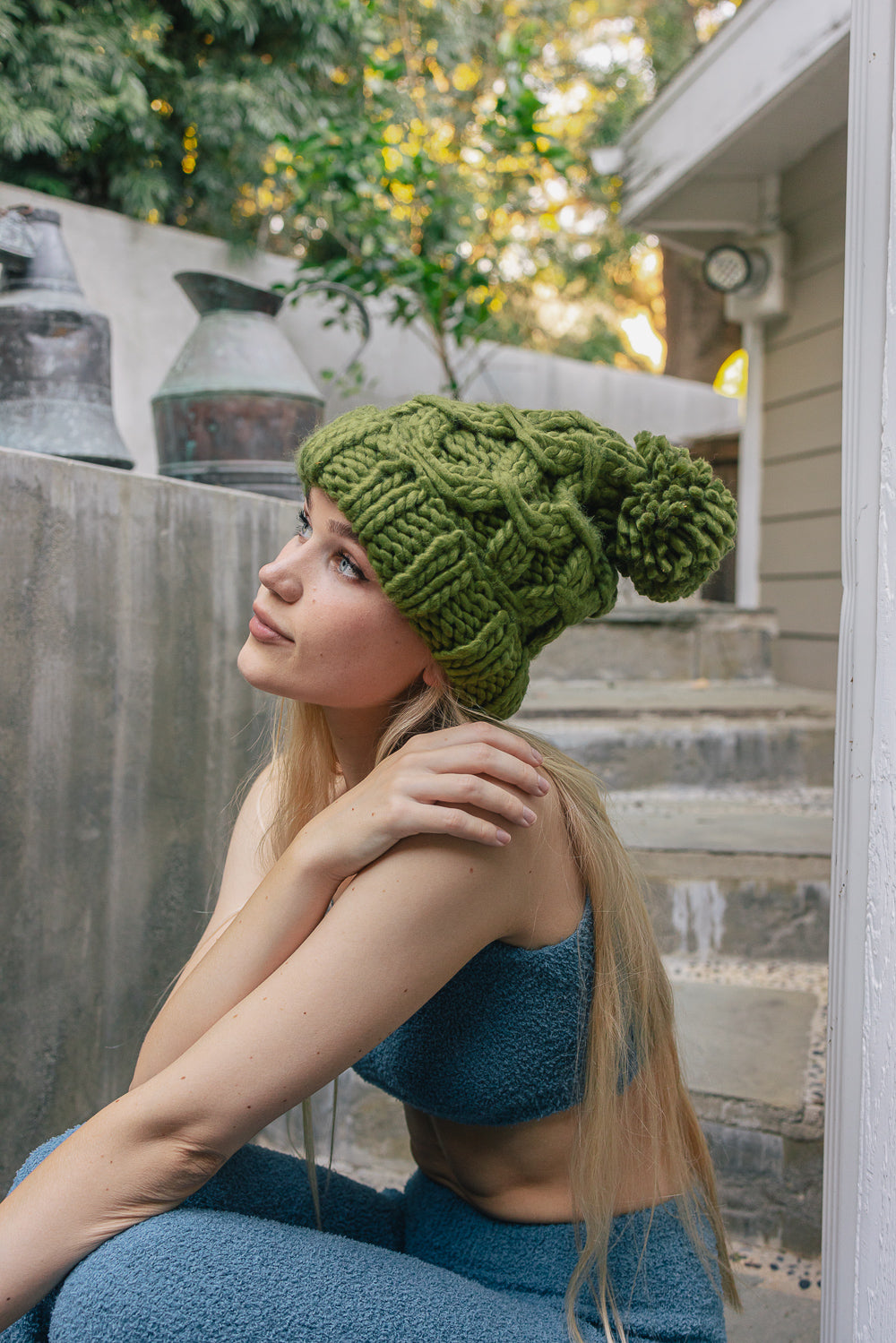 A stylish oversized chunky knit pom beanie in a cozy winter setting, featuring a playful pom on top and a chunky knit design.