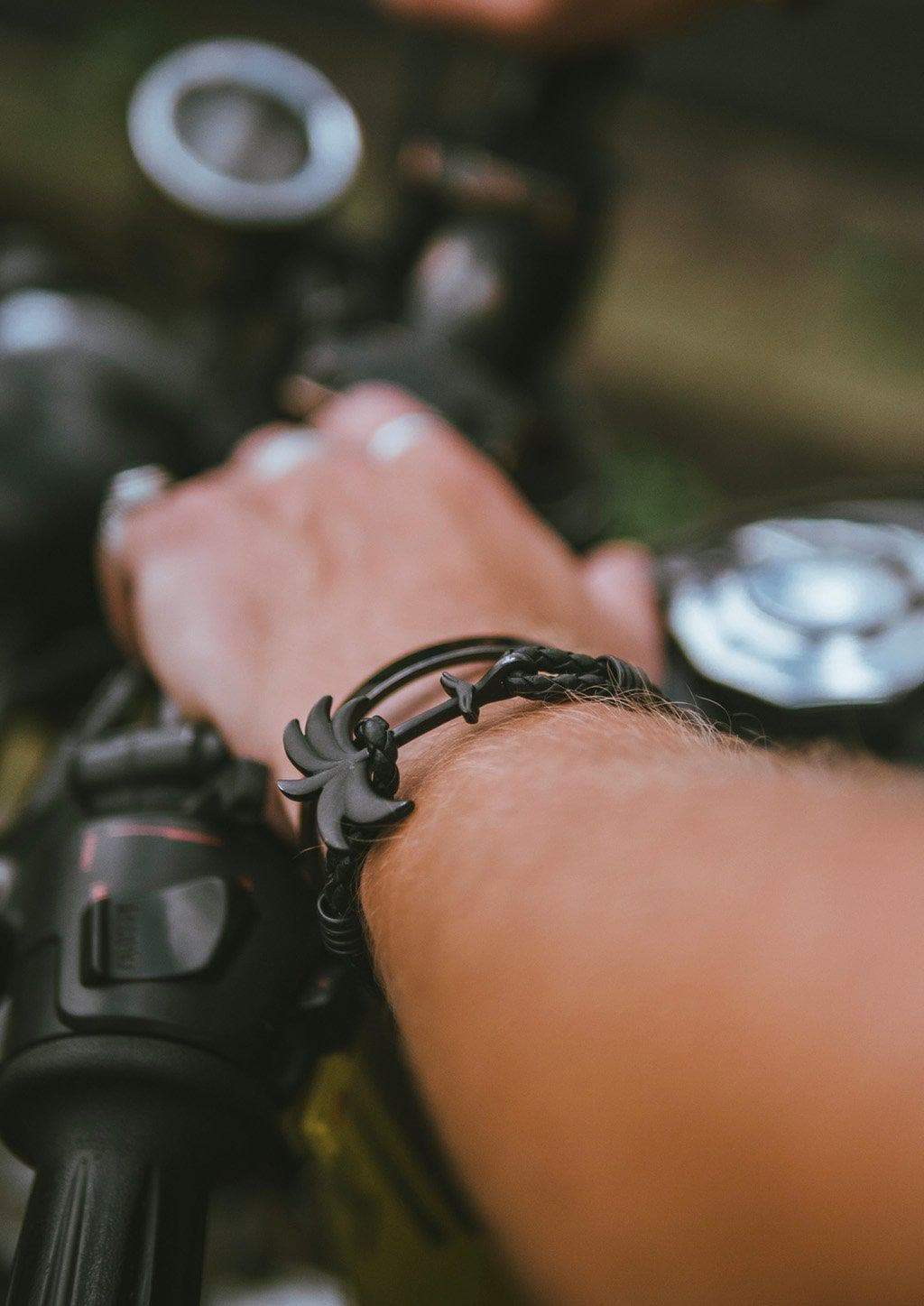 The Palm Band - Pitch Black featuring a matte black palm tree anchor on a thick braided black leather strap, showcasing its modern luxury design.