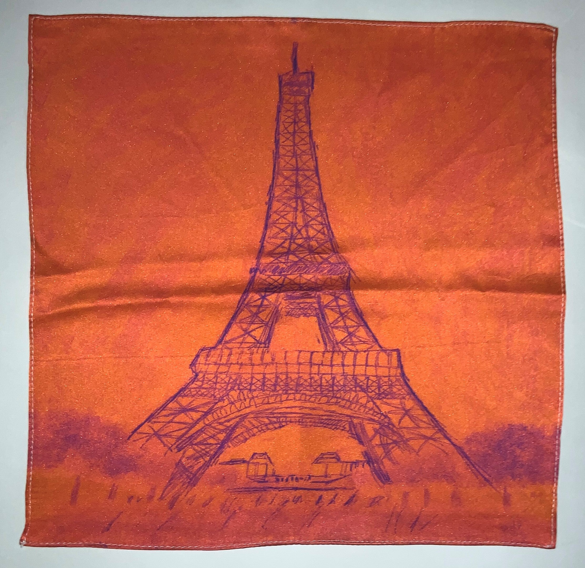 Burnt orange pocket square featuring a hand-sketched Eiffel Tower design and Gentleman Rogue logo.