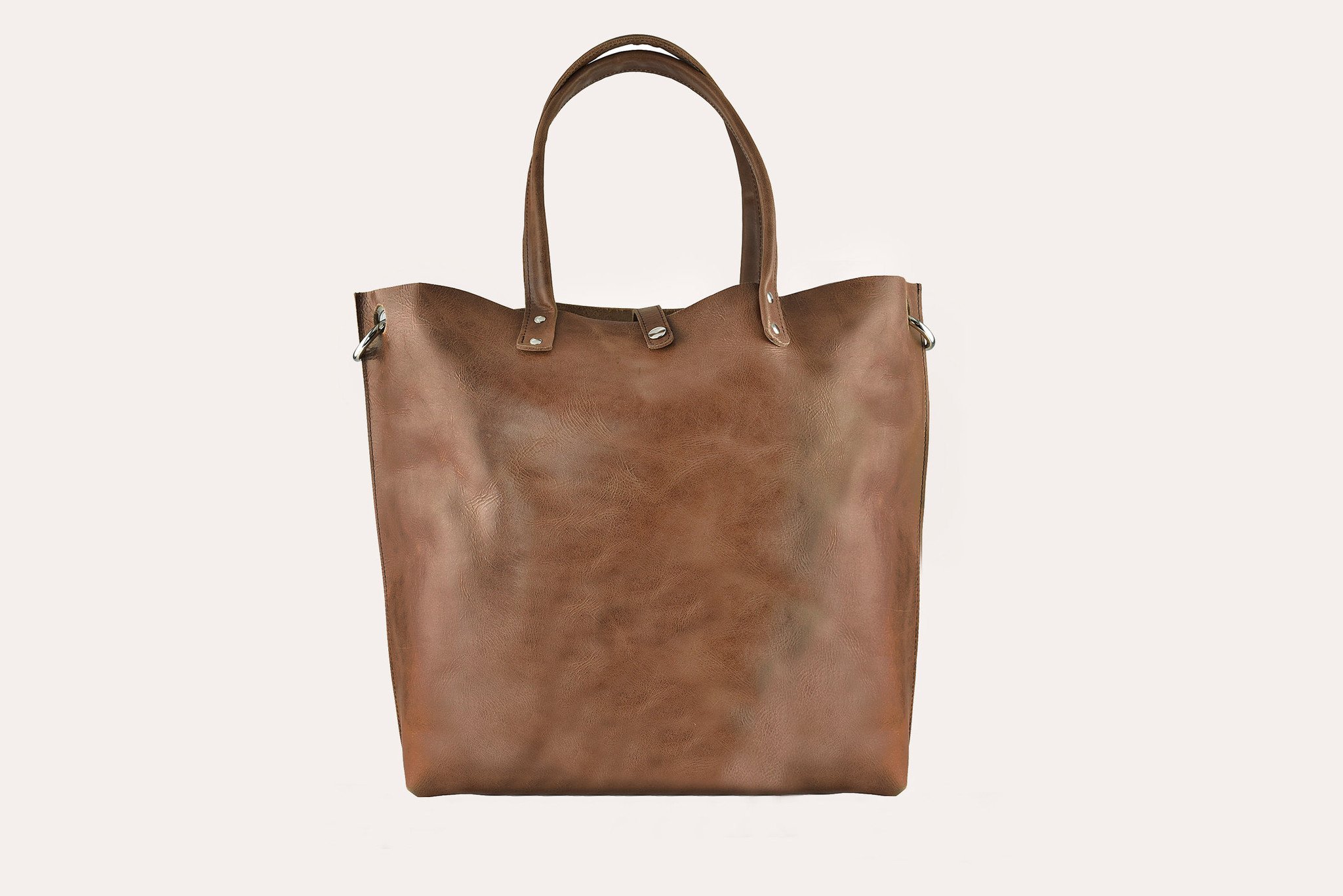 Paseo Tote made of smooth caramel leather with metallic details and removable shoulder strap.