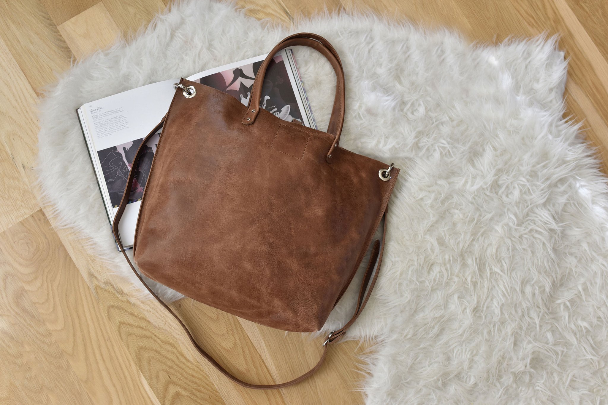 Paseo Tote made of smooth caramel leather with metallic details and removable shoulder strap.