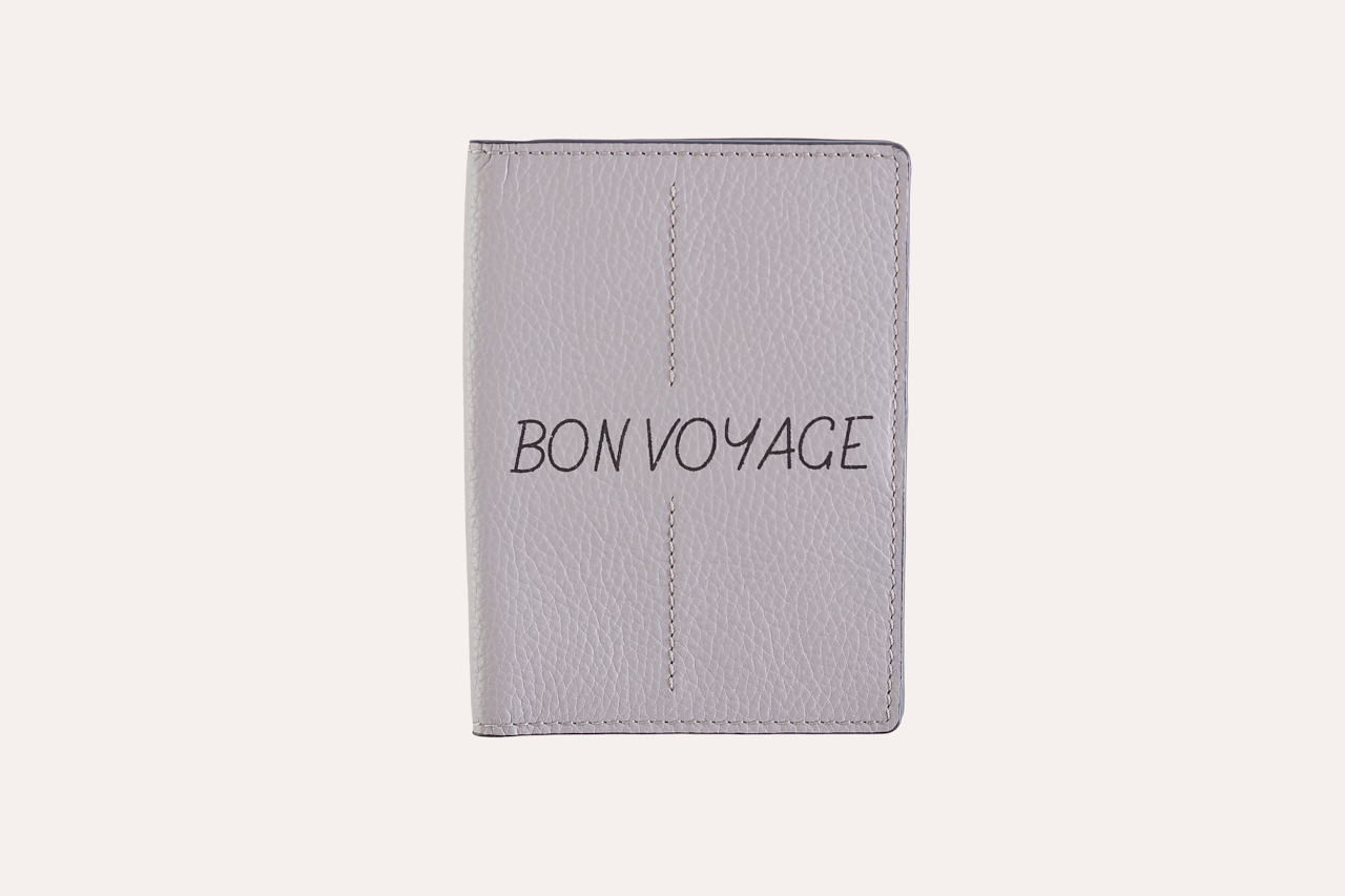 A stylish passport sleeve made of genuine pebble leather, featuring a button closure, card slots, and an external zipper pocket.