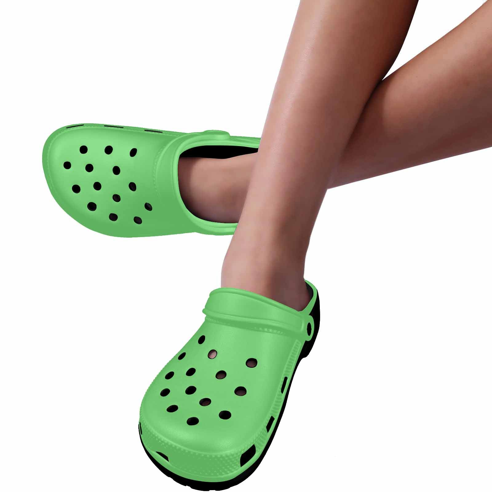 Pastel Green Adult Clogs made from lightweight EVA material, featuring ventilation ports and pivoting heel straps for a secure fit.