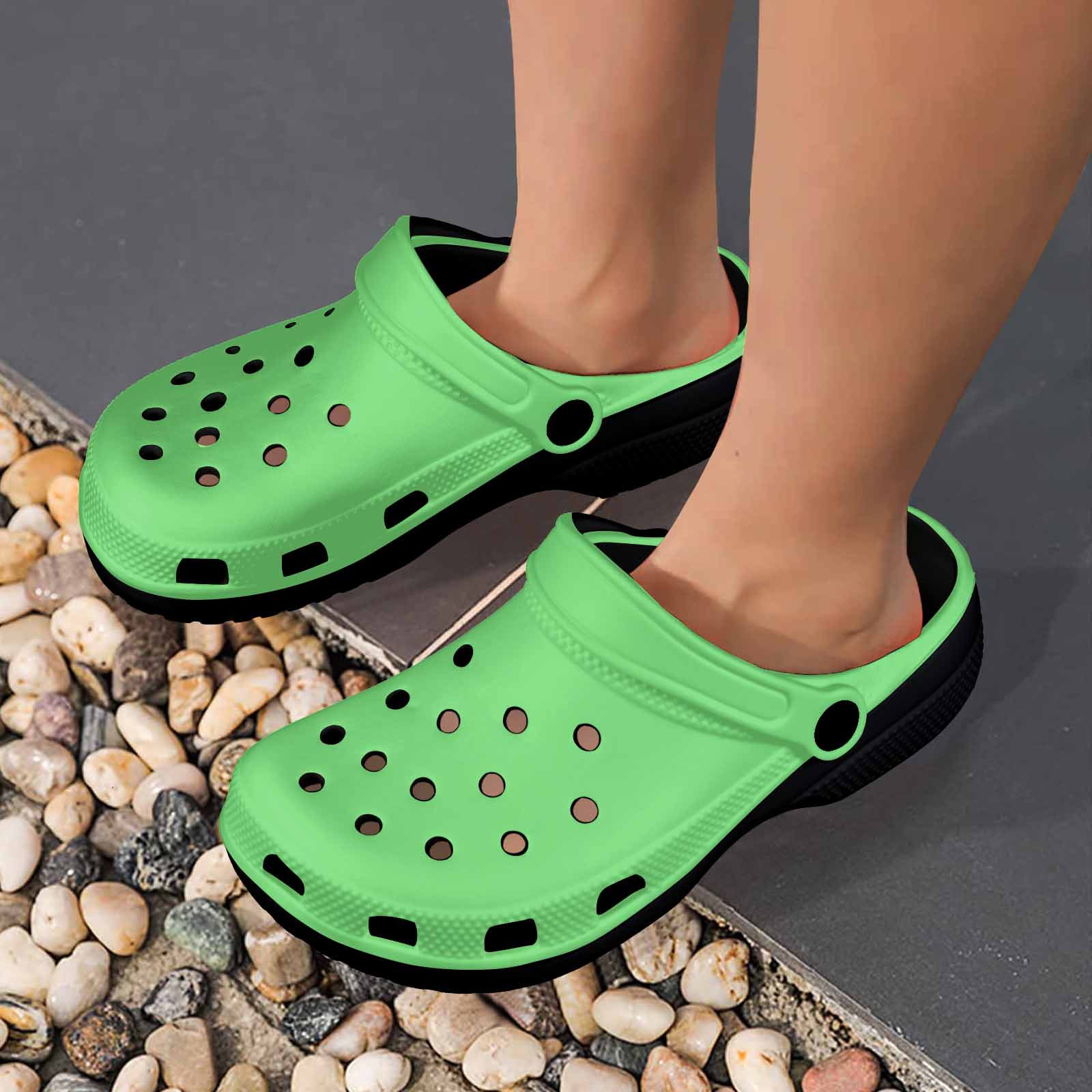 Pastel Green Adult Clogs made from lightweight EVA material, featuring ventilation ports and pivoting heel straps for a secure fit.