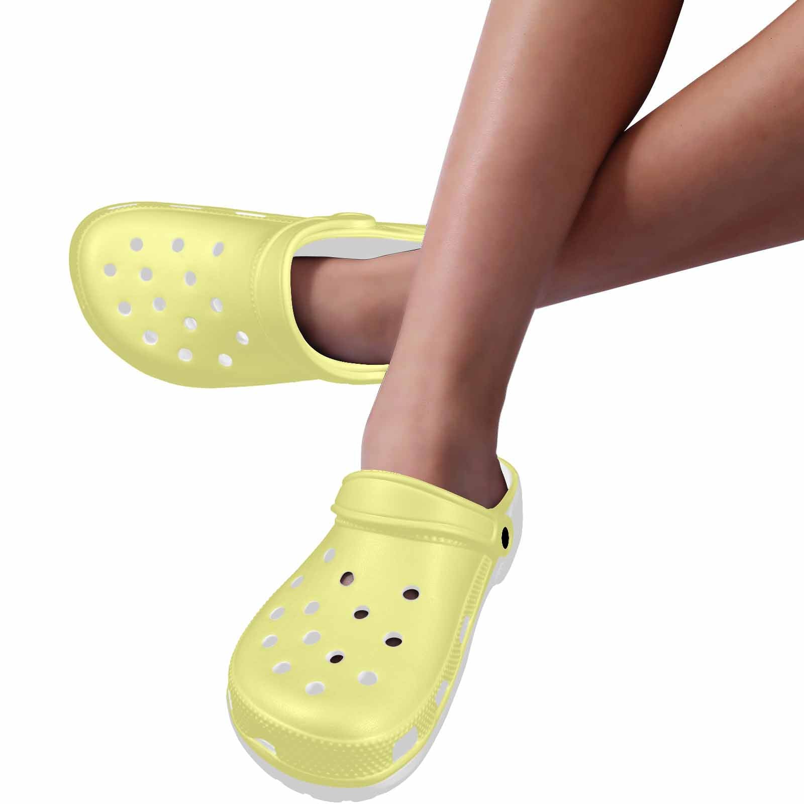 Pastel yellow adult clogs made from lightweight EVA material, featuring ventilation ports and pivoting heel straps for a secure fit.