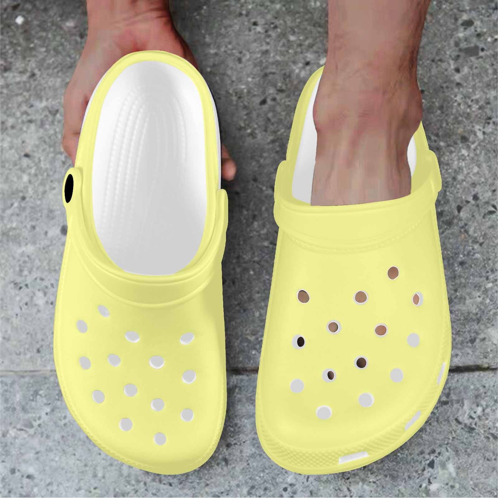 Pastel yellow adult clogs made from lightweight EVA material, featuring ventilation ports and pivoting heel straps for a secure fit.