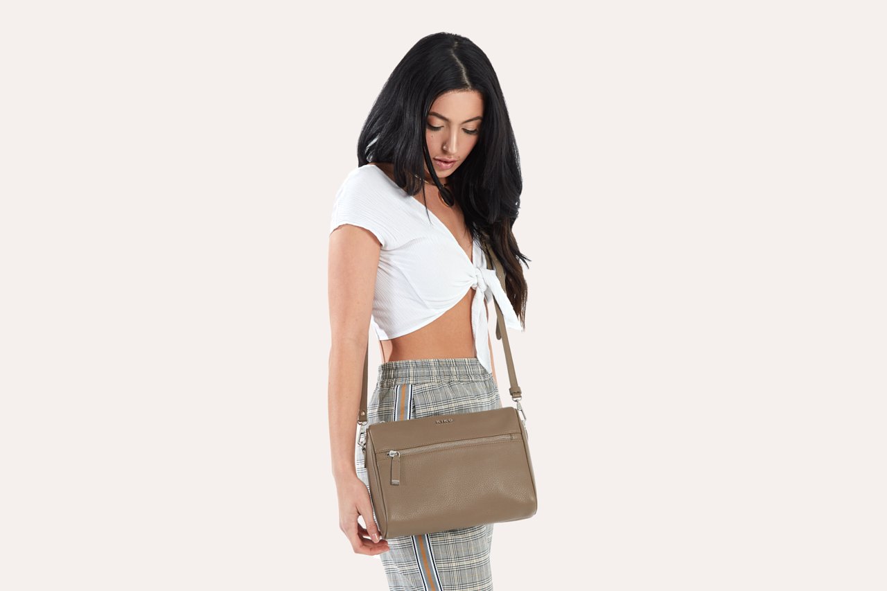 A stylish Perfect Crossbody bag made from genuine pebble leather, featuring an adjustable strap and multiple pockets for organization.