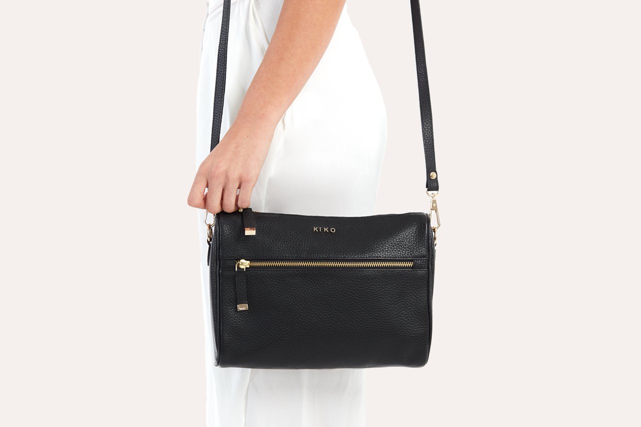 A stylish Perfect Crossbody bag made from genuine pebble leather, featuring an adjustable strap and multiple pockets for organization.