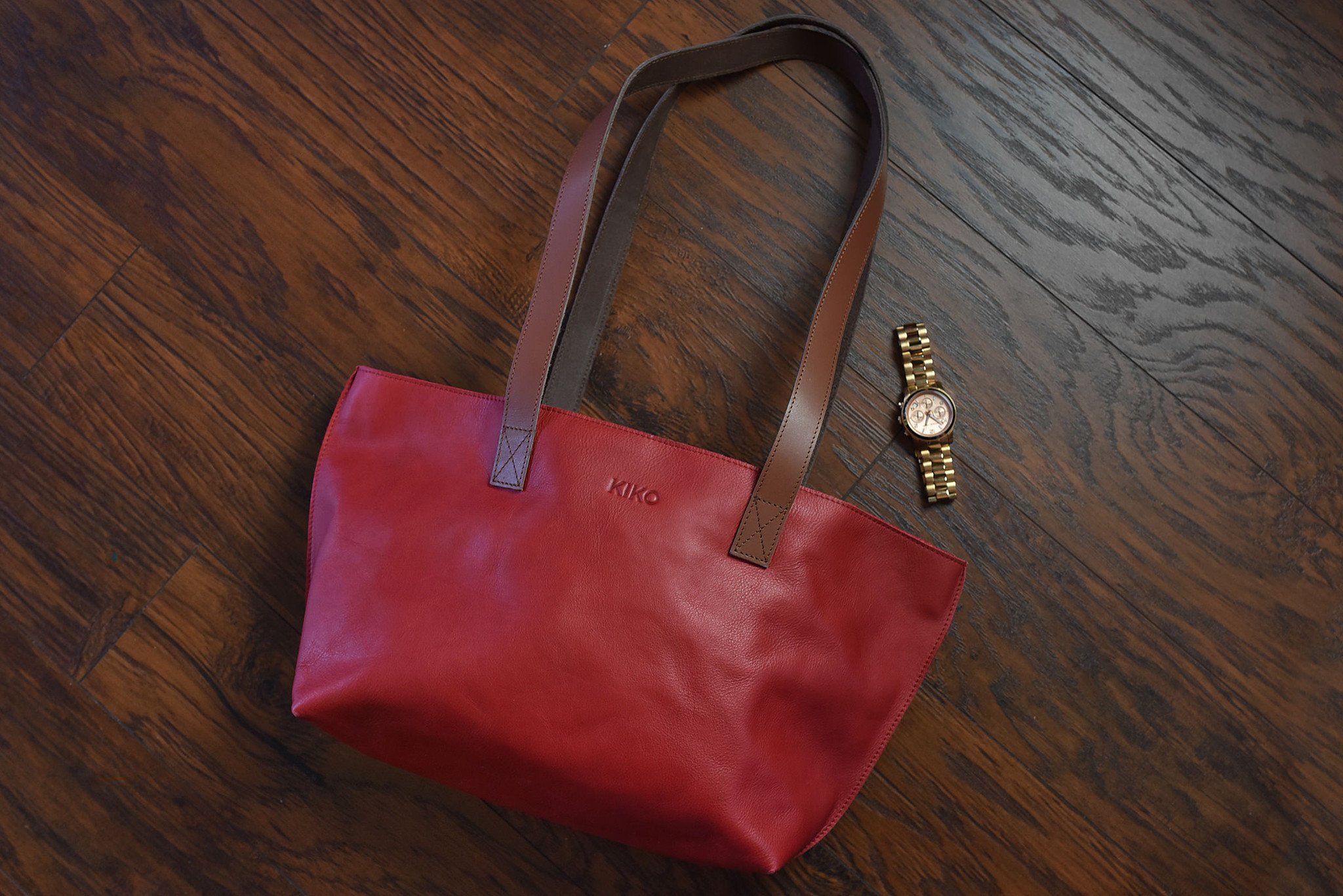 A stylish red tote bag made of genuine leather with a bowl-shaped design and comfortable shoulder handles.