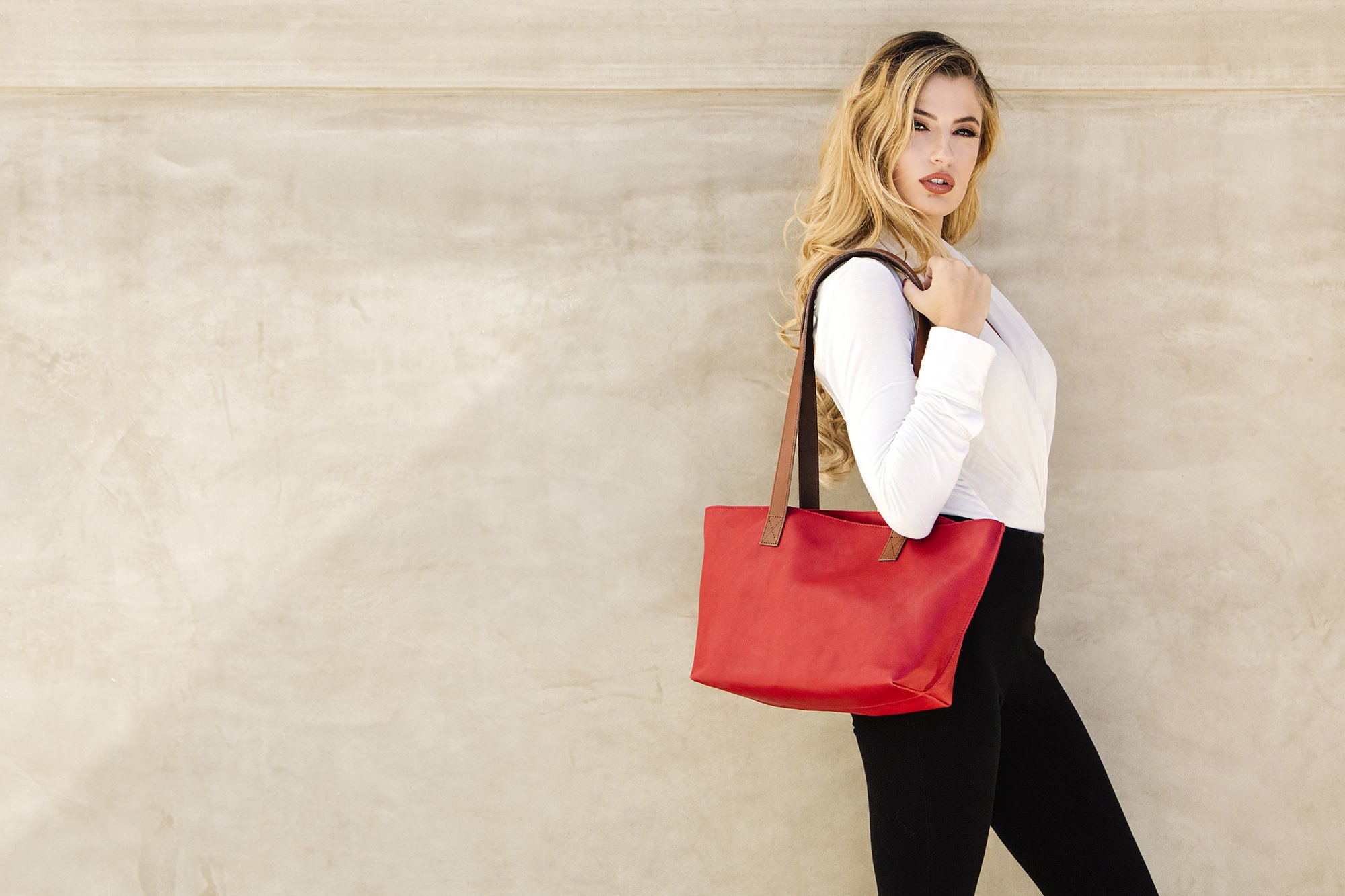 A stylish red tote bag made of genuine leather with a bowl-shaped design and comfortable shoulder handles.