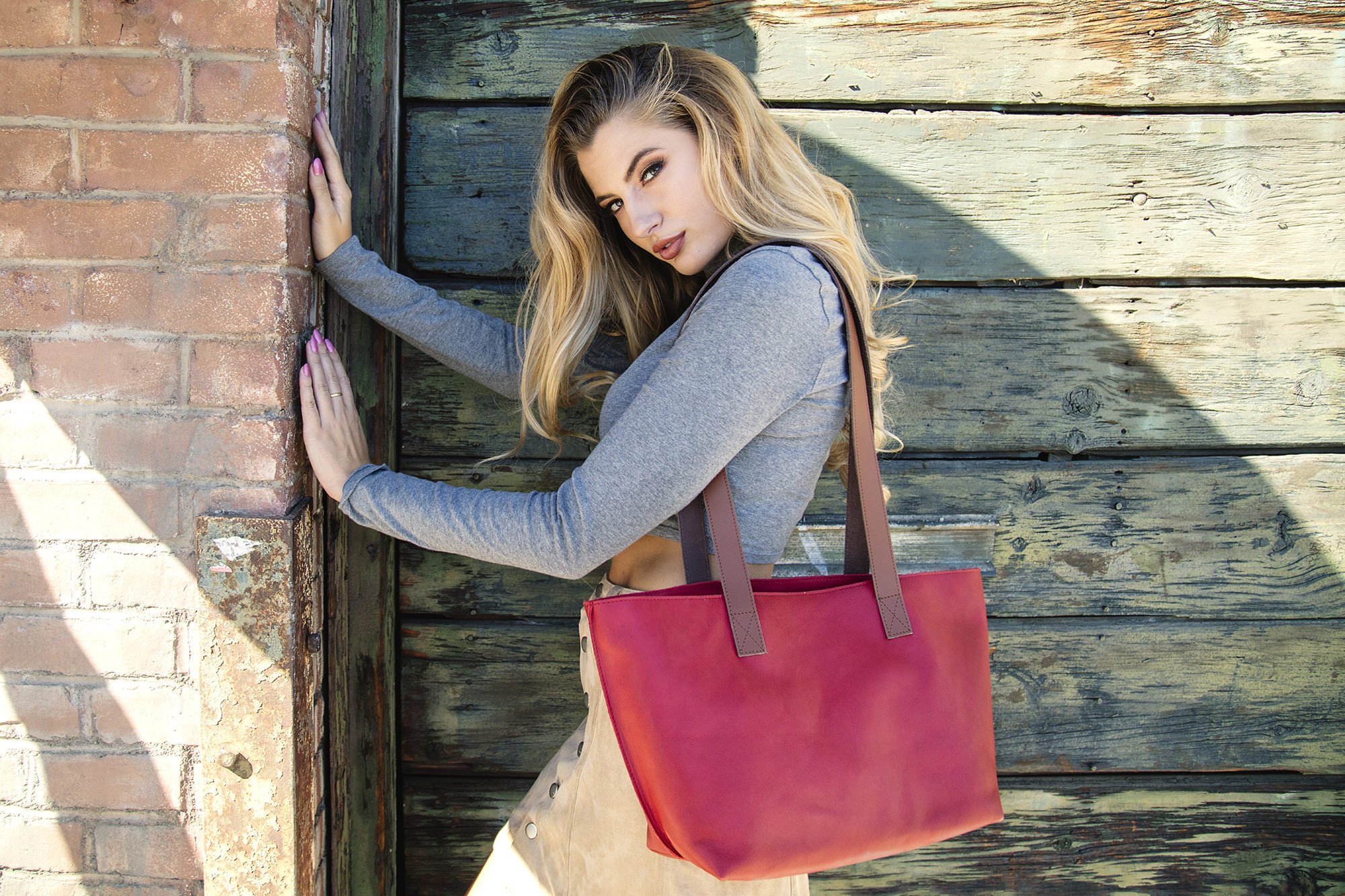 A stylish red tote bag made of genuine leather with a bowl-shaped design and comfortable shoulder handles.