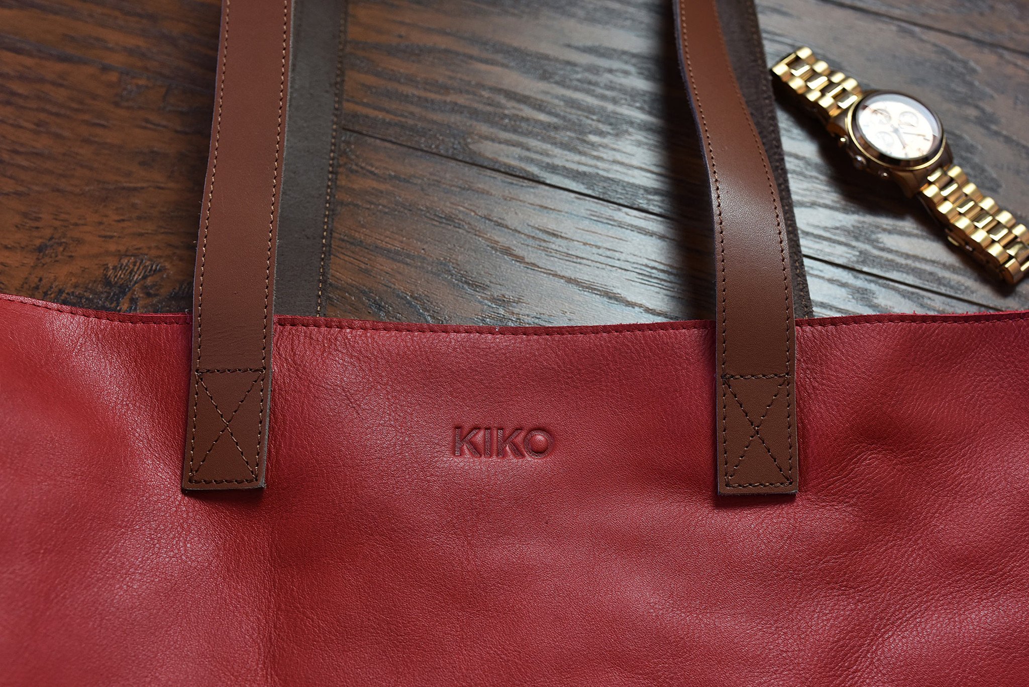 A stylish red tote bag made of genuine leather with a bowl-shaped design and comfortable shoulder handles.