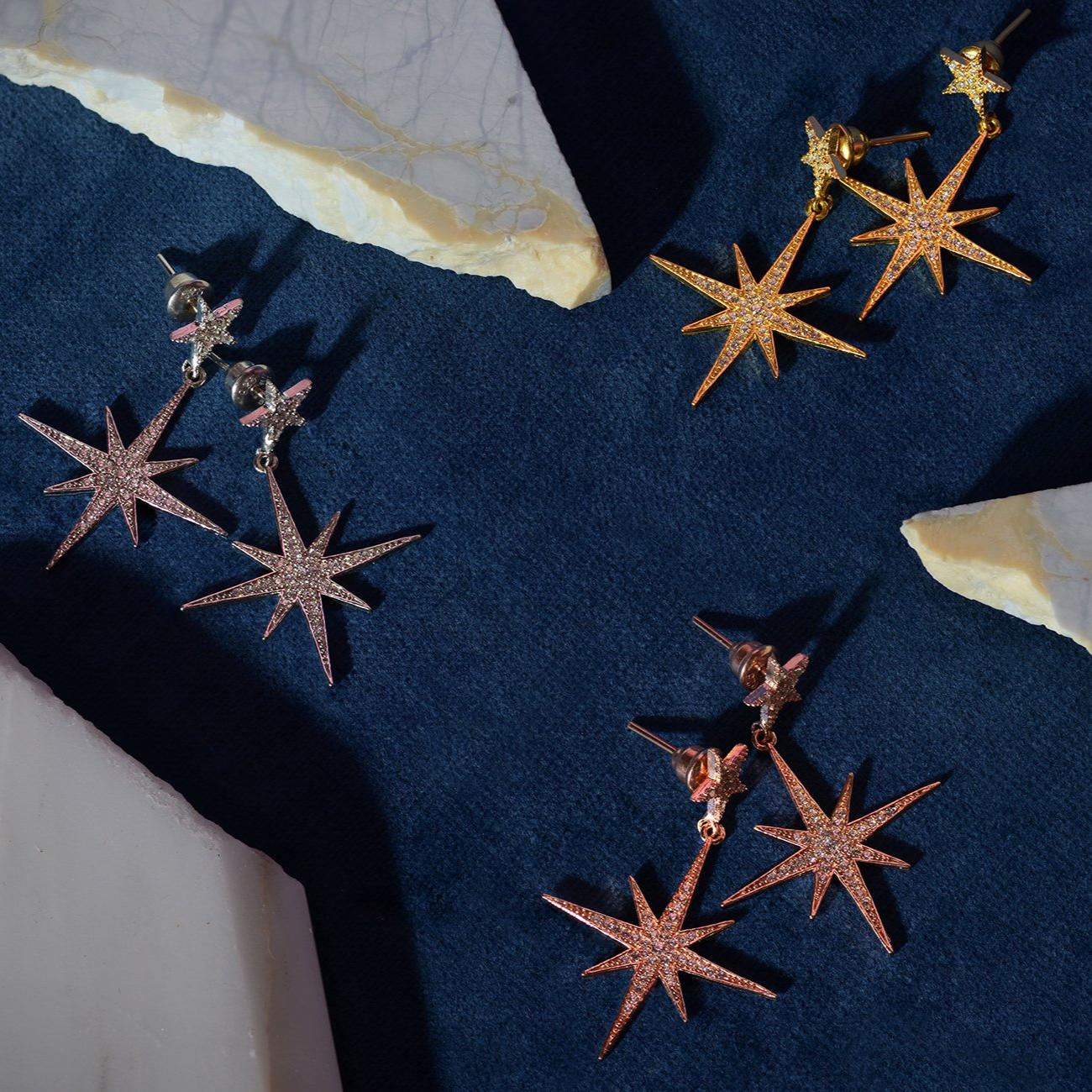 Petite Star Burst Drop Earrings in Rosegold featuring a larger starburst and smaller stud, adorned with cubic zirconia for added sparkle.