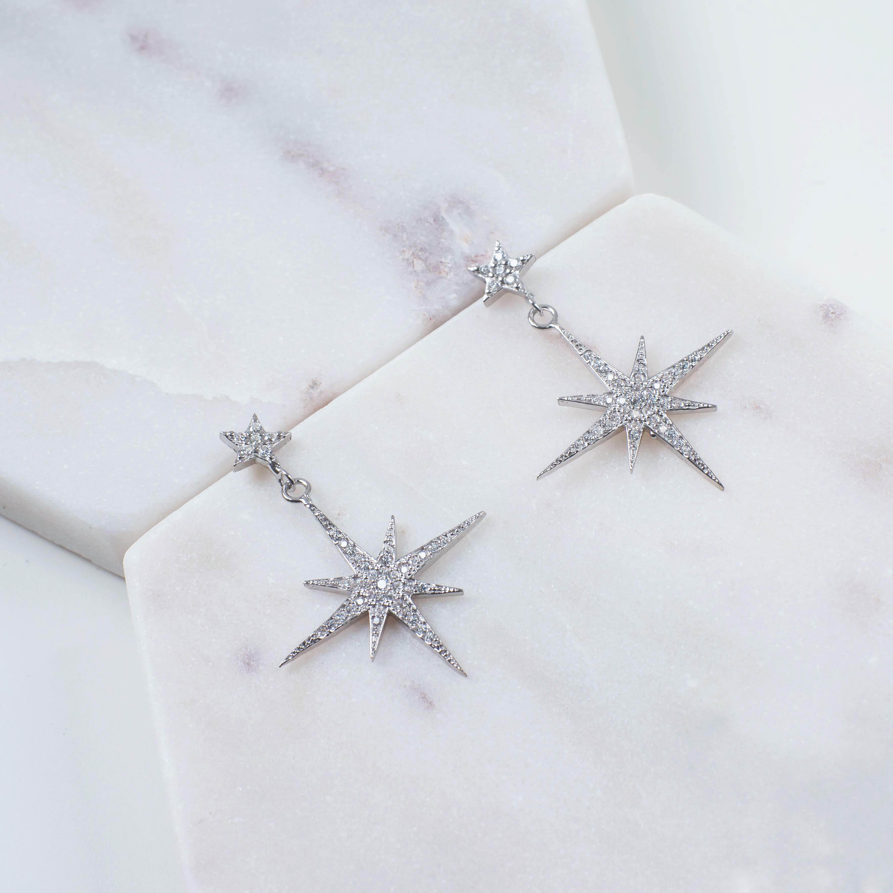 Petite Star Burst Drop Earrings in Silver featuring sparkling cubic zirconia and a unique starburst design.