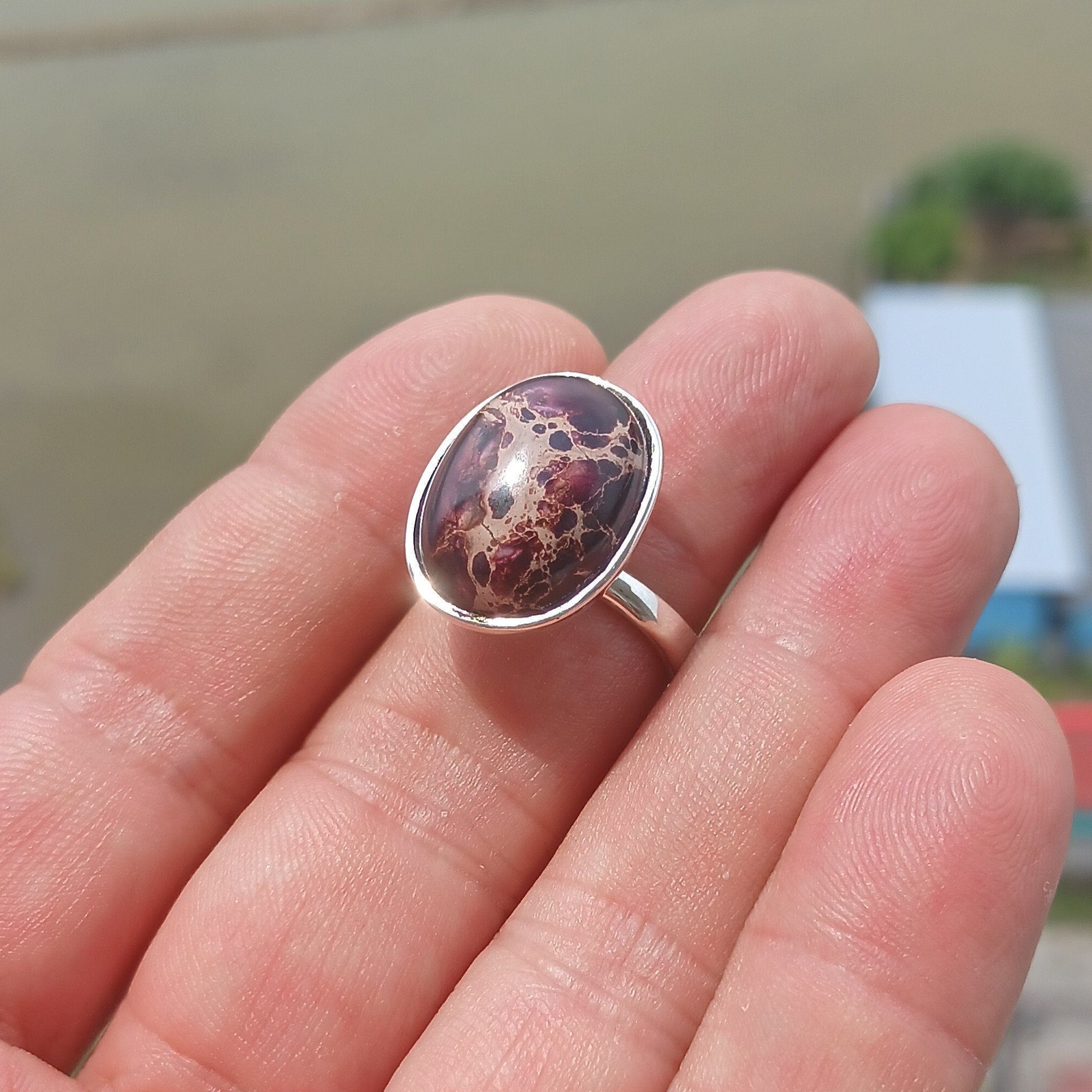 A beautiful sterling silver ring featuring a vibrant oval-shaped purple Pietersite gemstone, showcasing its unique design and craftsmanship.