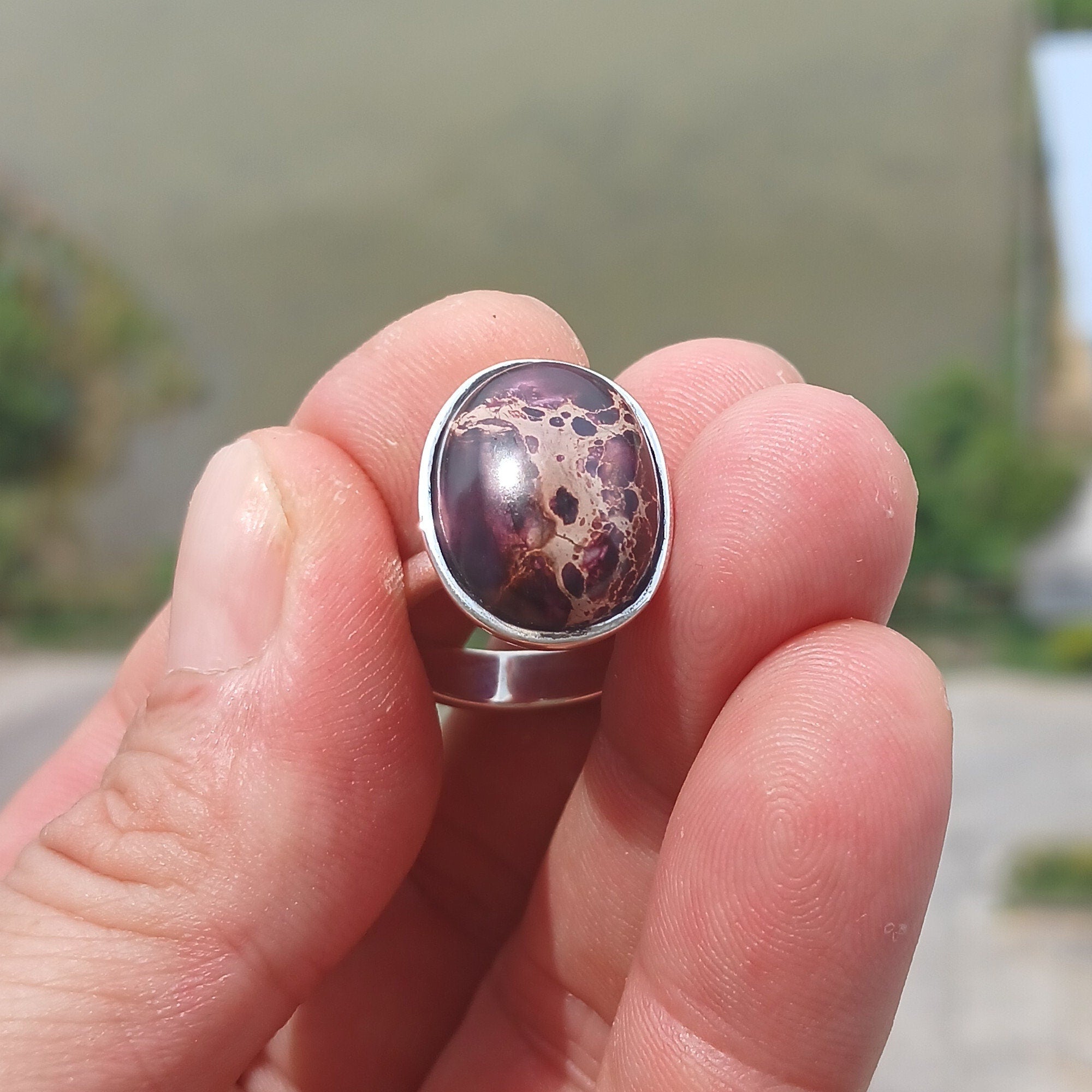 A beautiful sterling silver ring featuring a vibrant oval-shaped purple Pietersite gemstone, showcasing its unique design and craftsmanship.