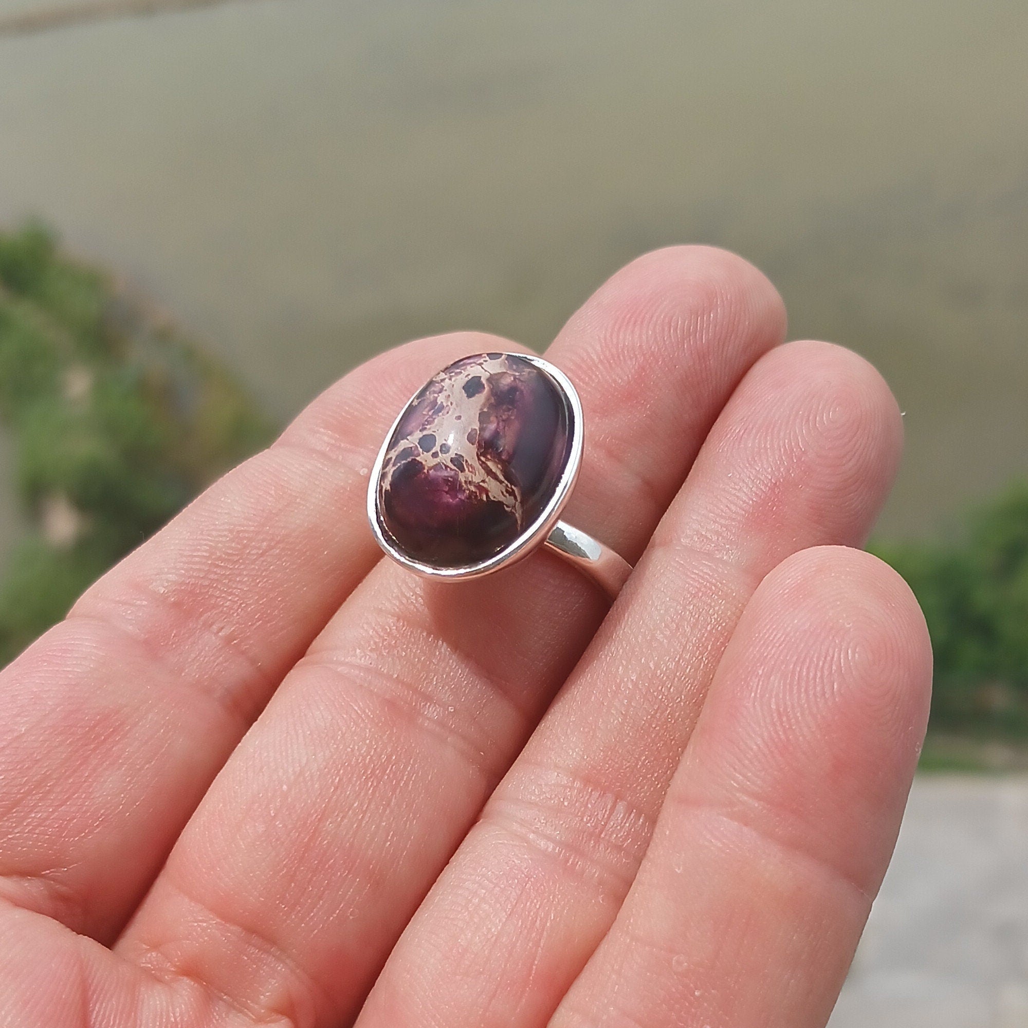 A beautiful sterling silver ring featuring a vibrant oval-shaped purple Pietersite gemstone, showcasing its unique design and craftsmanship.