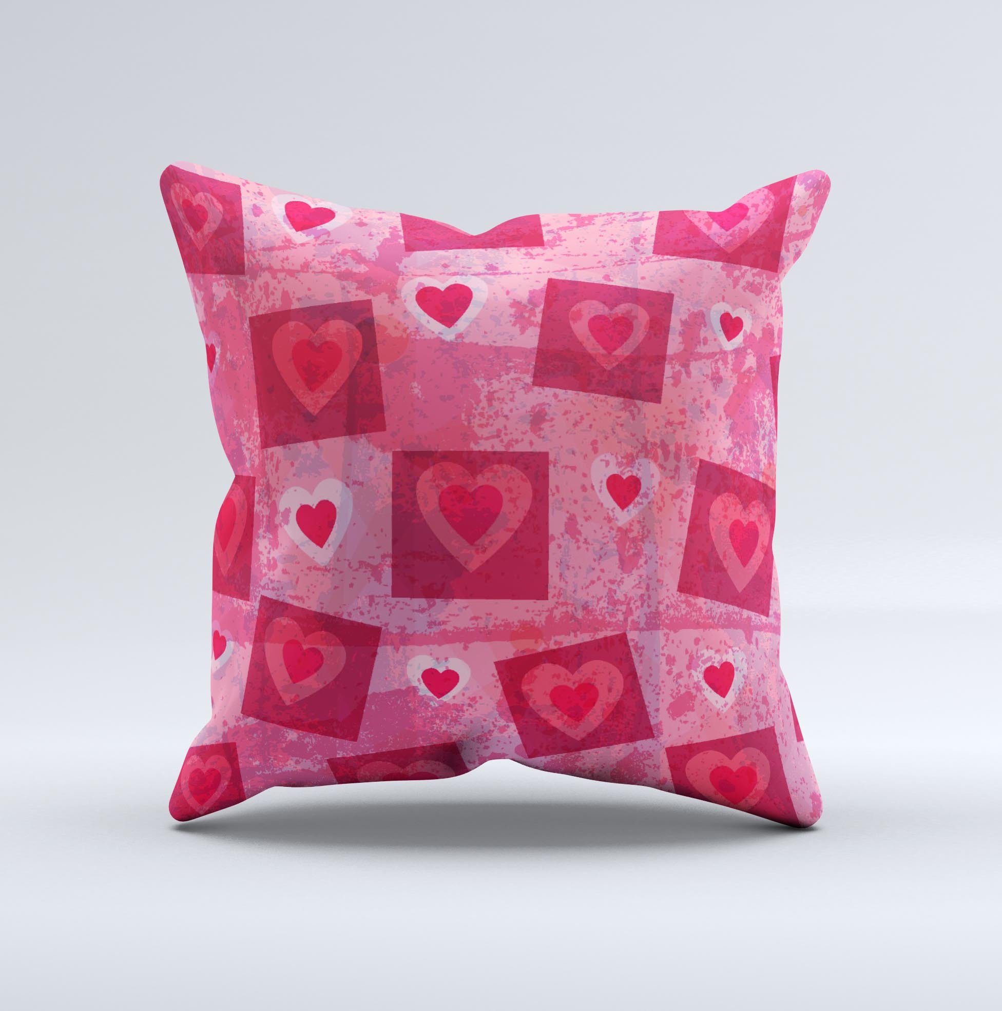 A decorative throw pillow featuring a unique design of pink and red hearts arranged in blocks, handcrafted in Virginia.