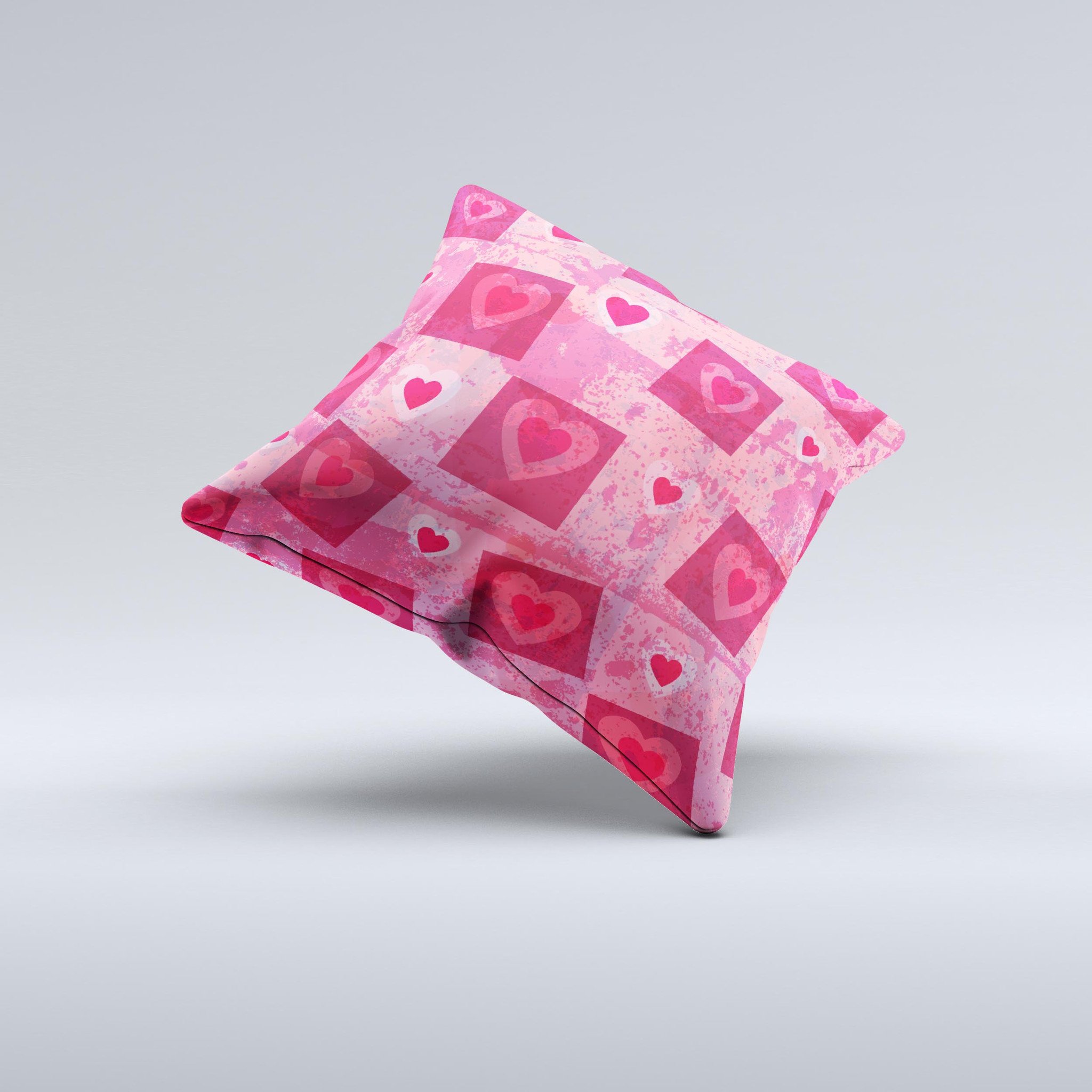 A decorative throw pillow featuring a unique design of pink and red hearts arranged in blocks, handcrafted in Virginia.