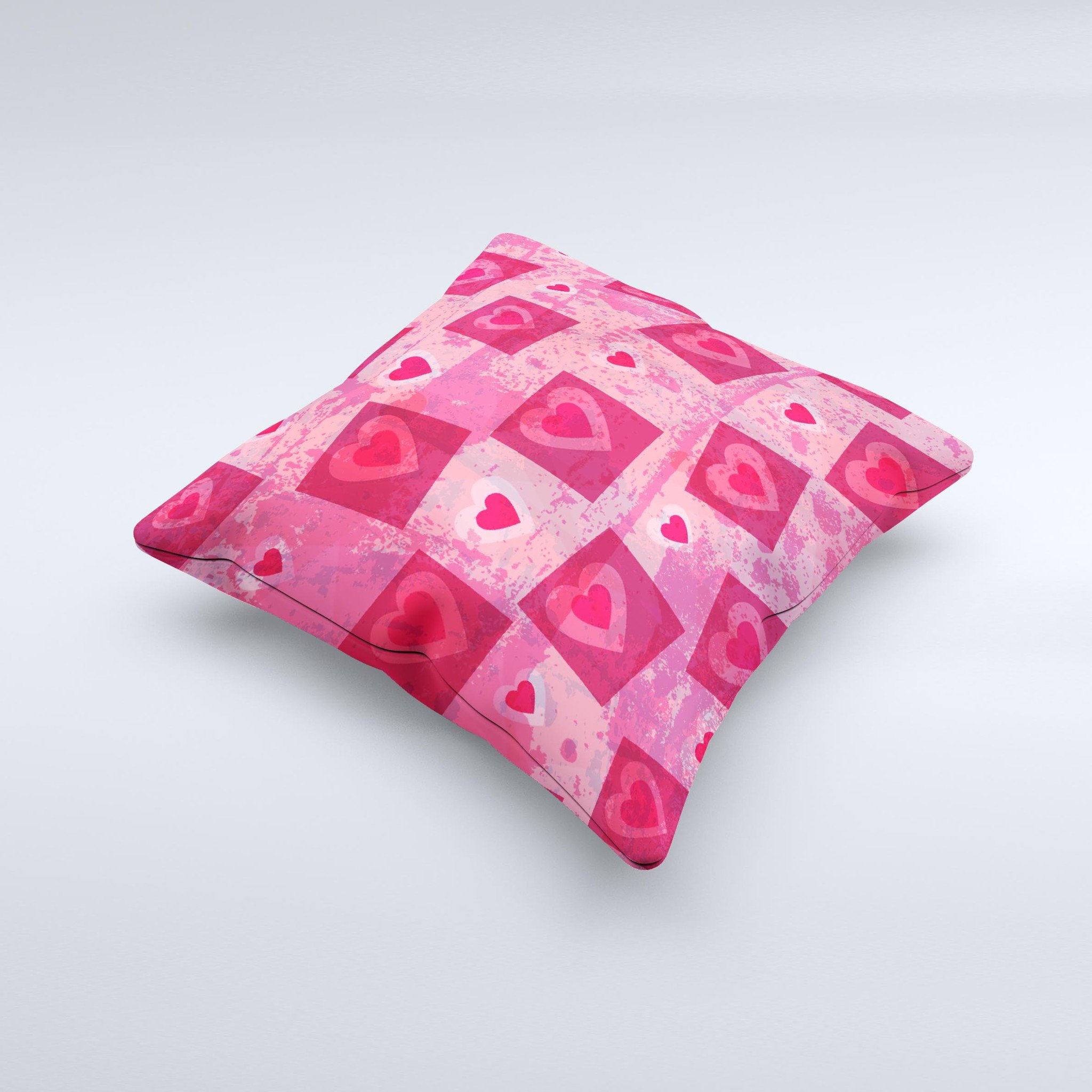 A decorative throw pillow featuring a unique design of pink and red hearts arranged in blocks, handcrafted in Virginia.