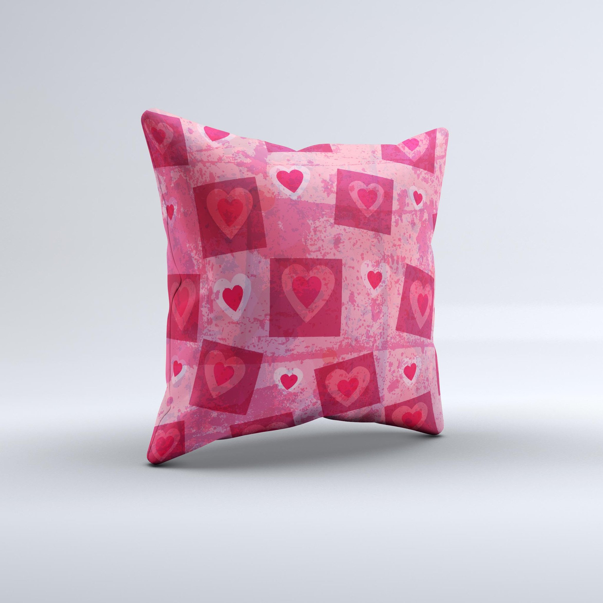 A decorative throw pillow featuring a unique design of pink and red hearts arranged in blocks, handcrafted in Virginia.