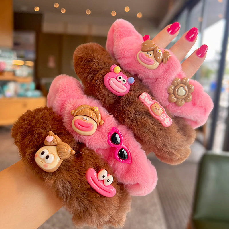 A cute pink and brown plush clown hair tie featuring fuzzy gloves, perfect for adding a playful touch to hairstyles.