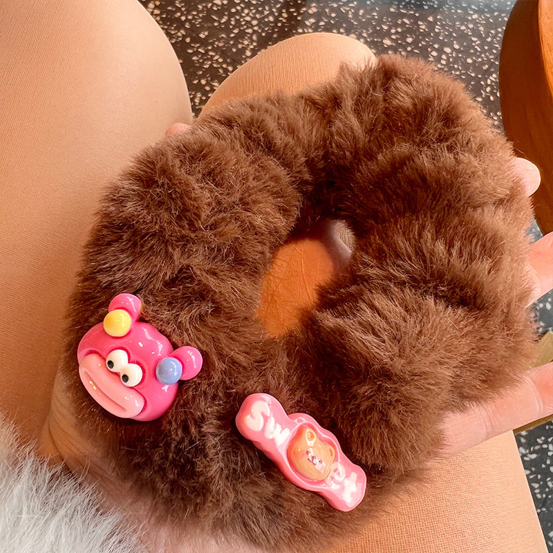 A cute pink and brown plush clown hair tie featuring fuzzy gloves, perfect for adding a playful touch to hairstyles.