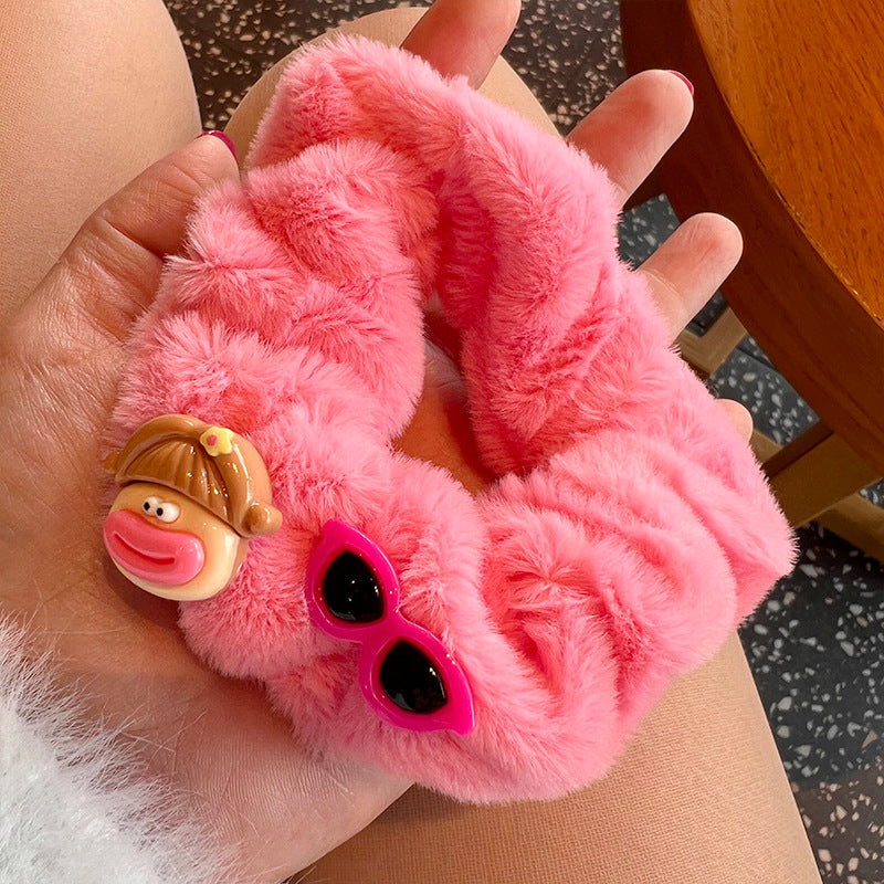 A cute pink and brown plush clown hair tie featuring fuzzy gloves, perfect for adding a playful touch to hairstyles.