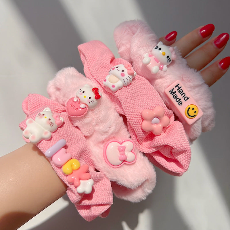 A vibrant pink hair tie featuring fuzzy textures, held by a woman's hand, showcasing a playful and unique design.