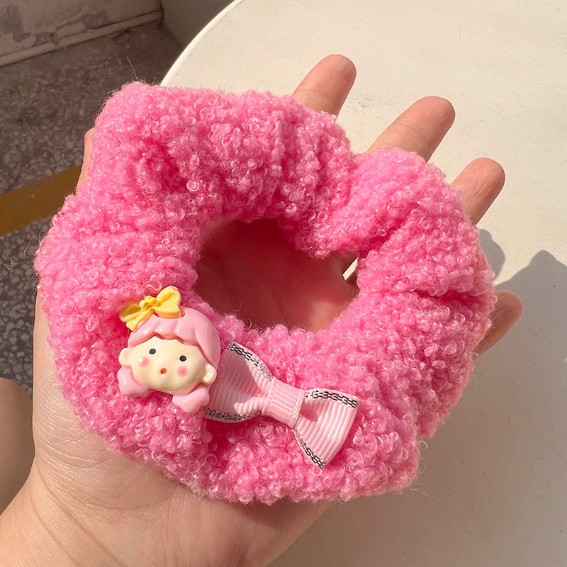 A pair of pink curly plush hair ties featuring cartoon characters, perfect for adding charm to hairstyles.