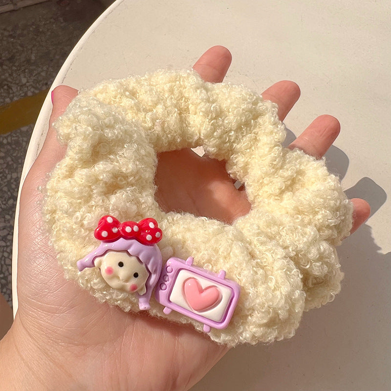 A pair of pink curly plush hair ties featuring cartoon characters, perfect for adding charm to hairstyles.