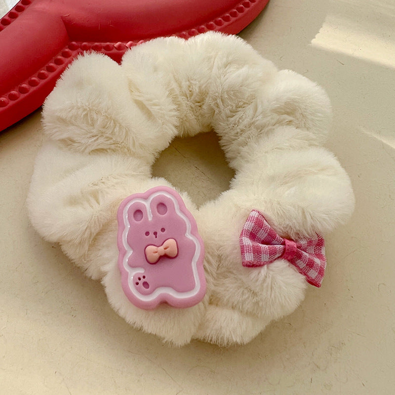 A pink and white plush hair tie featuring a cute animal design, perfect for adding a playful touch to hairstyles.