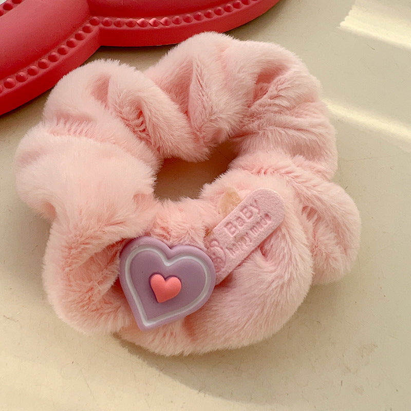 A pink and white plush hair tie featuring a cute animal design, perfect for adding a playful touch to hairstyles.