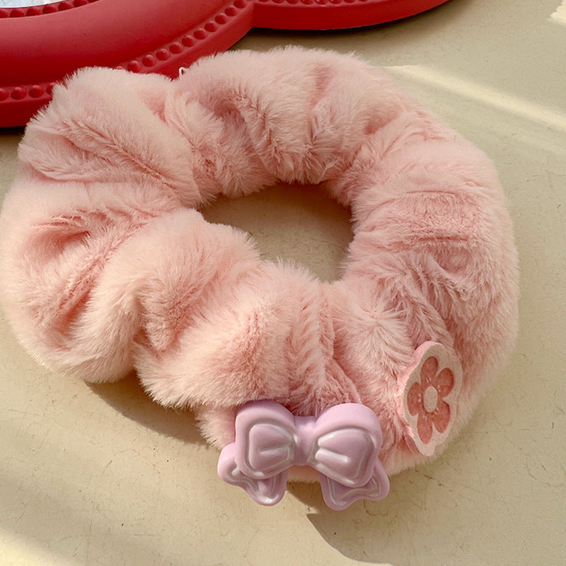 A pink and white plush hair tie featuring a cute animal design, perfect for adding a playful touch to hairstyles.