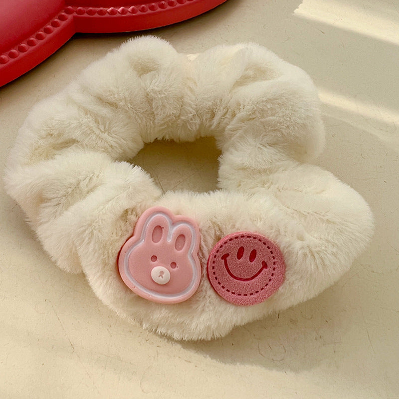 A pink and white plush hair tie featuring a cute animal design, perfect for adding a playful touch to hairstyles.