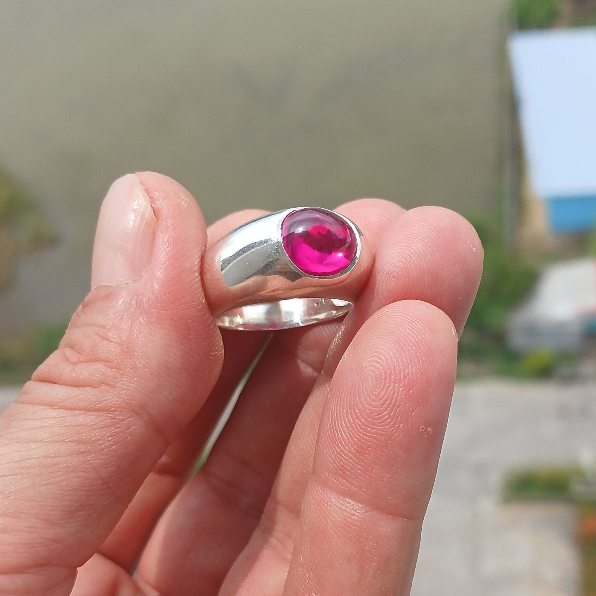 A beautiful Pink CZ Cabochon Ring made of sterling silver, featuring an oval-shaped pink gemstone in a minimalist solitaire design.