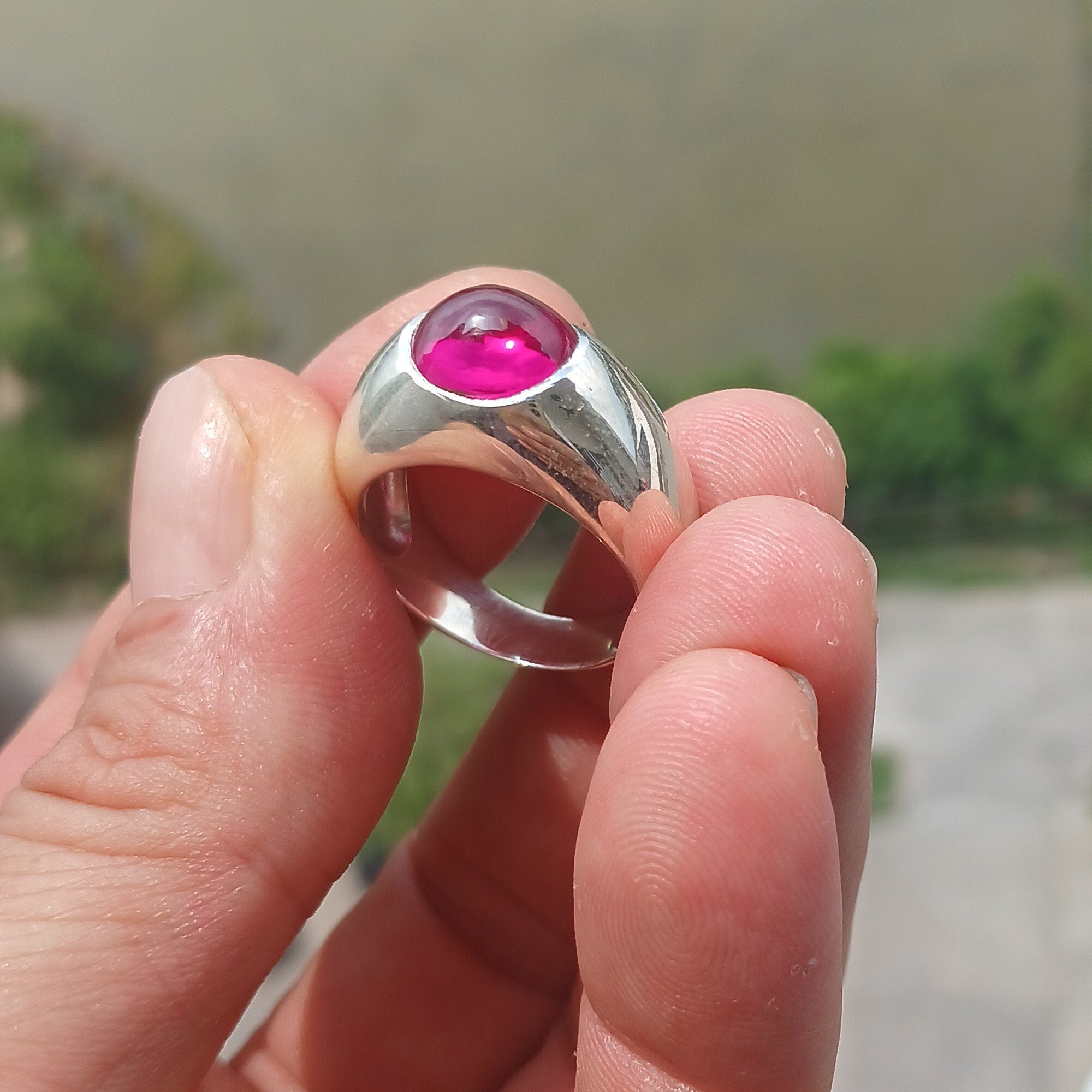 A beautiful Pink CZ Cabochon Ring made of sterling silver, featuring an oval-shaped pink gemstone in a minimalist solitaire design.