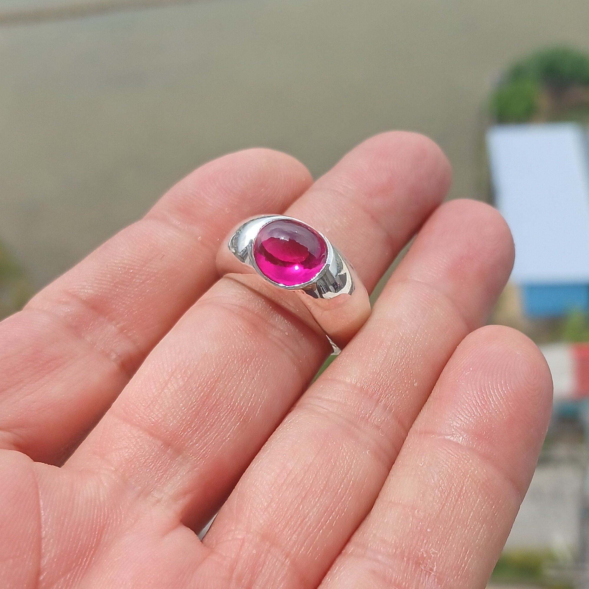 A beautiful Pink CZ Cabochon Ring made of sterling silver, featuring an oval-shaped pink gemstone in a minimalist solitaire design.