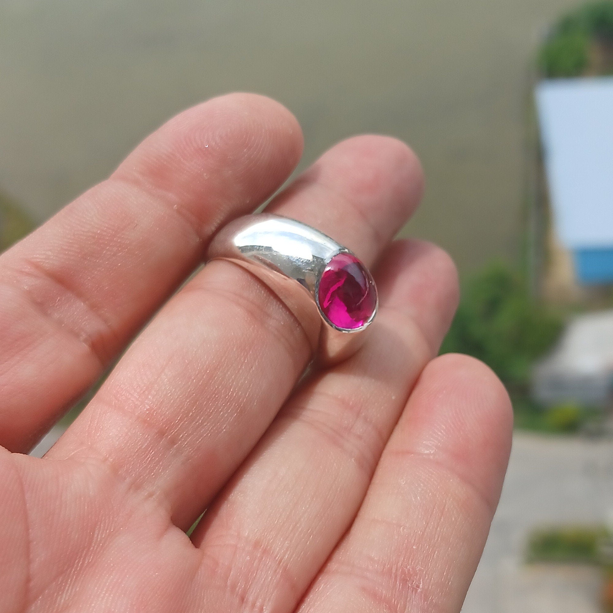 A beautiful Pink CZ Cabochon Ring made of sterling silver, featuring an oval-shaped pink gemstone in a minimalist solitaire design.