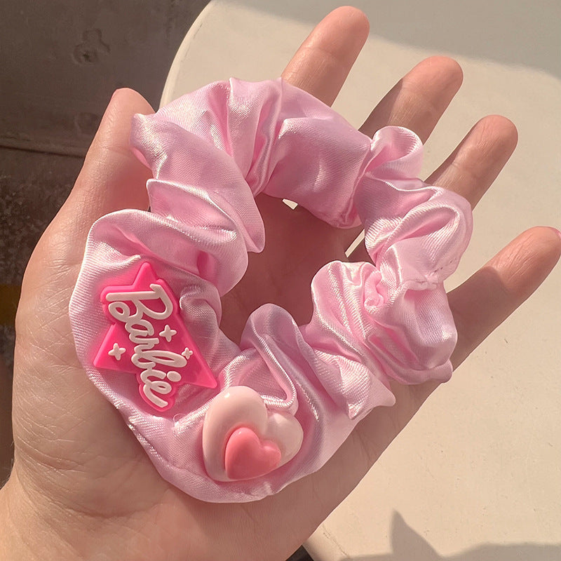 A stylish pink hair tie with a unique textured design, perfect for securing hair in place while adding a fashionable touch.